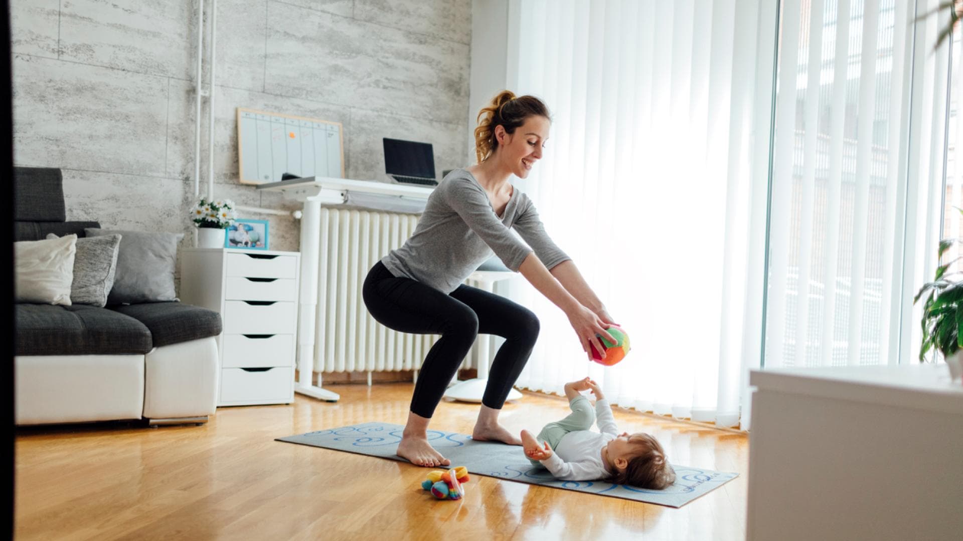 Mutter macht Kniebeuge beim Spielen mit Kind