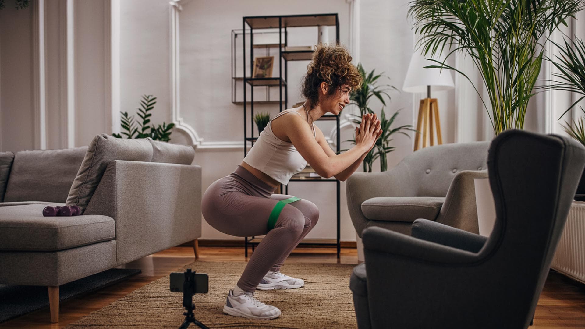 Frau macht Squats in der Wohnung