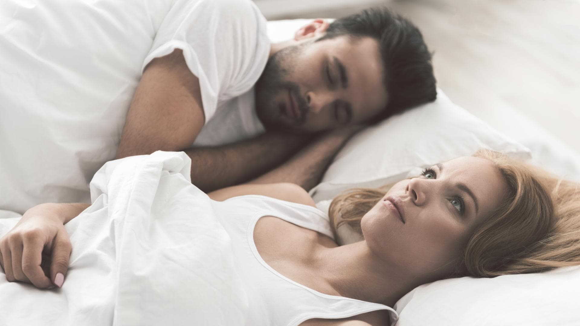 Frau liegt wach neben Mann Frau liegt wach neben Mann