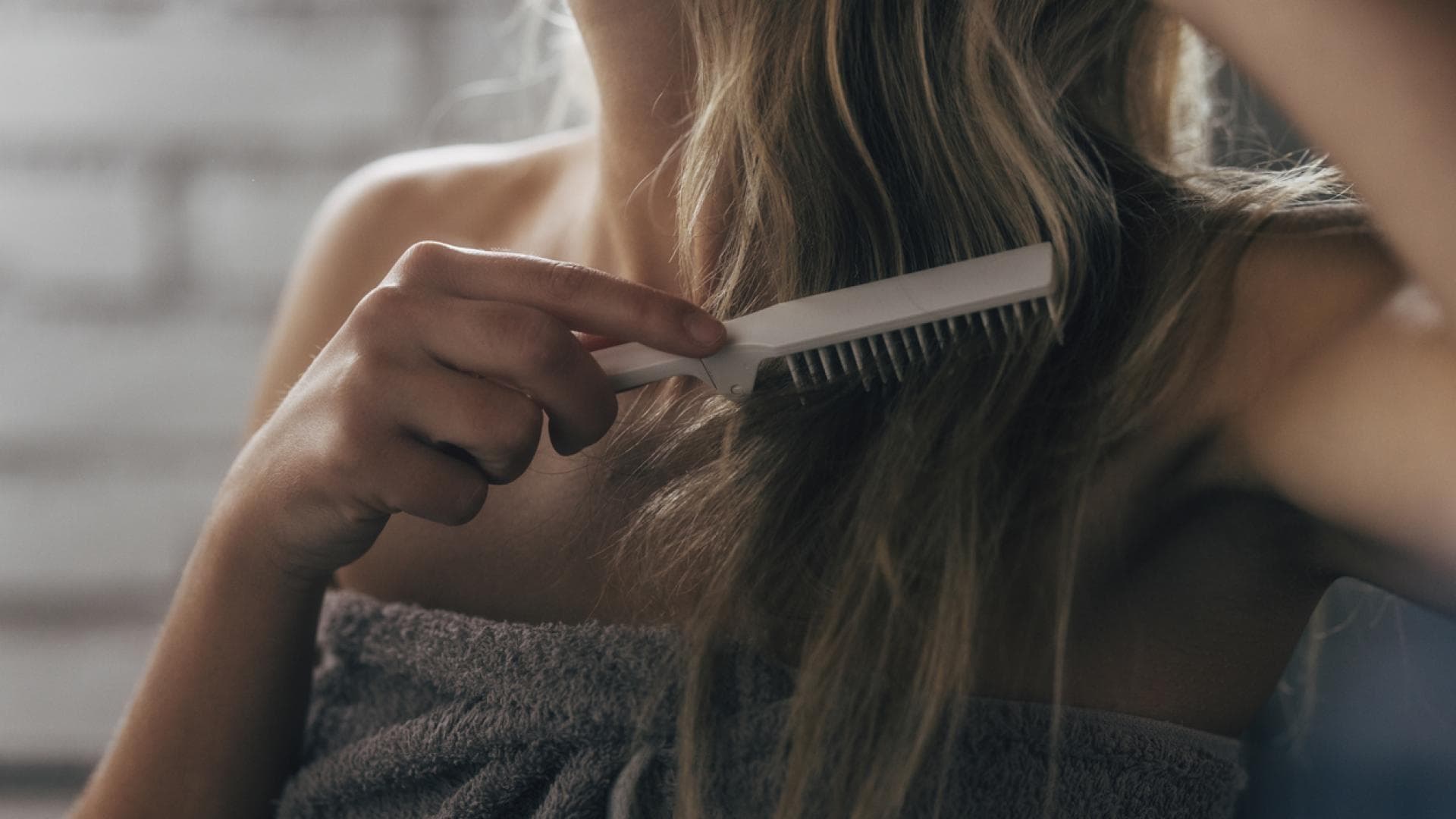 Frau kämmt sich Haare nach der Dusche