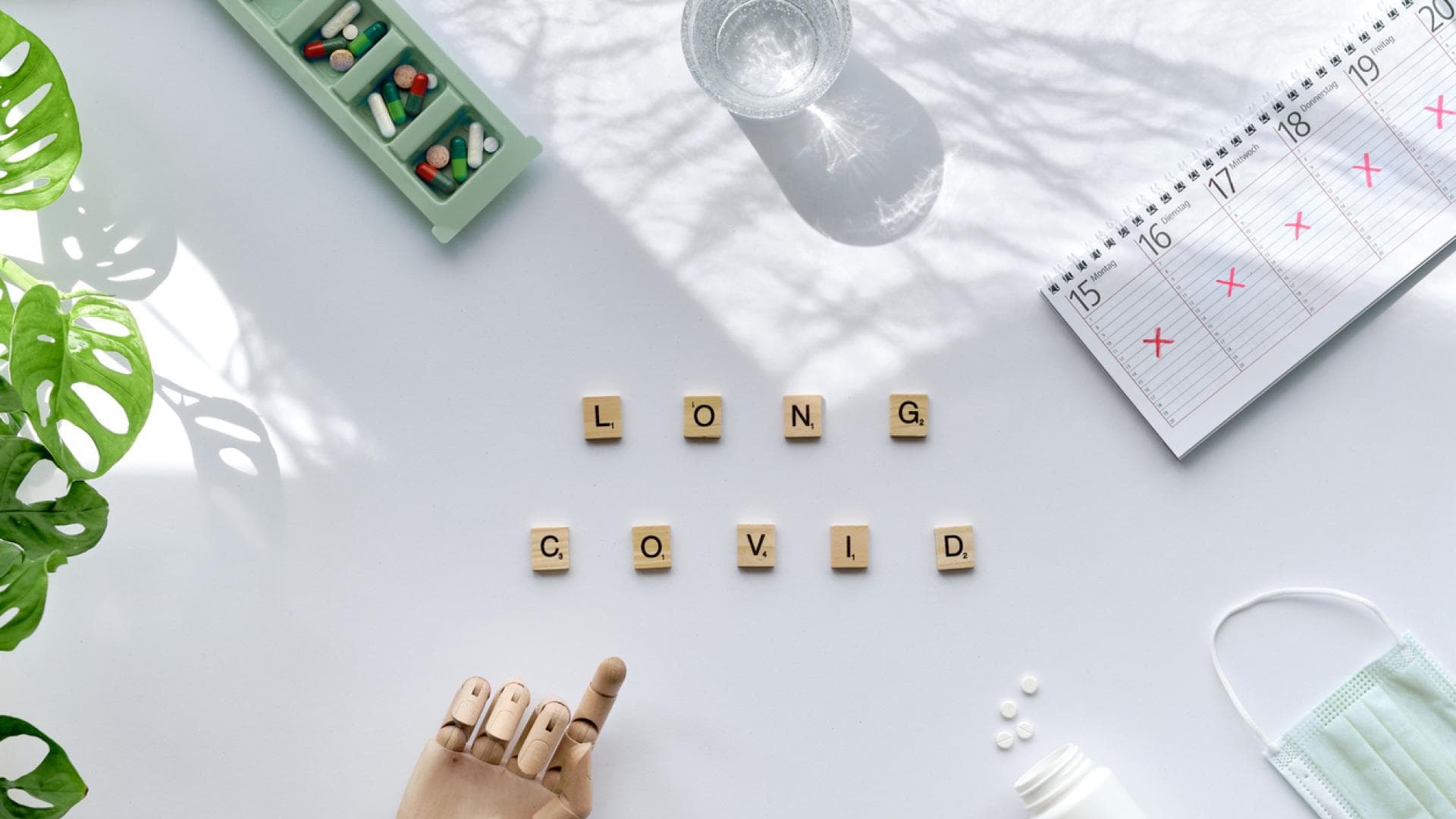 Top-Ansicht von Scrabblesteinen, die Long-Covid buchstabieren