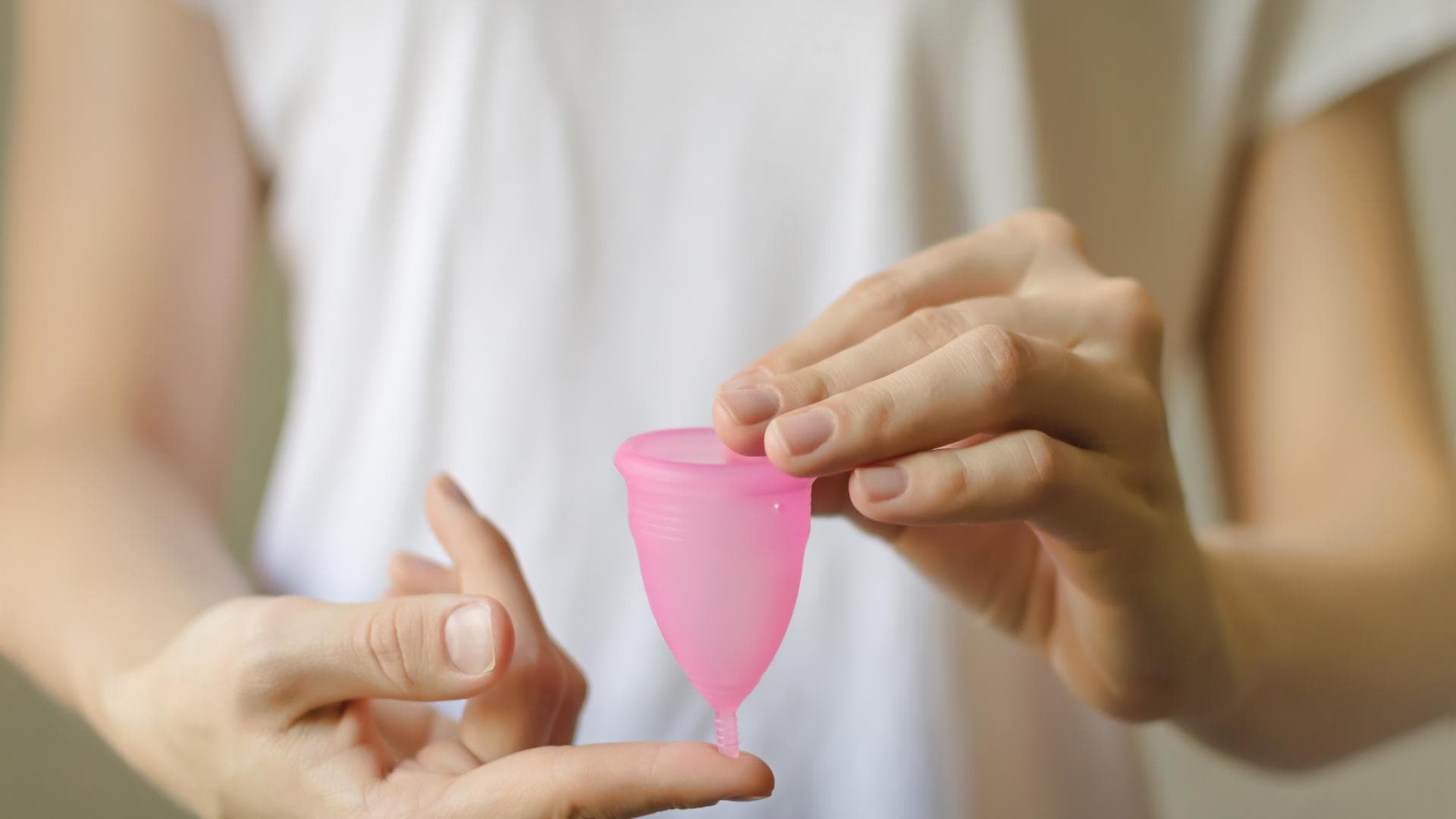 Frau hält Menstruationstasse in den Händen