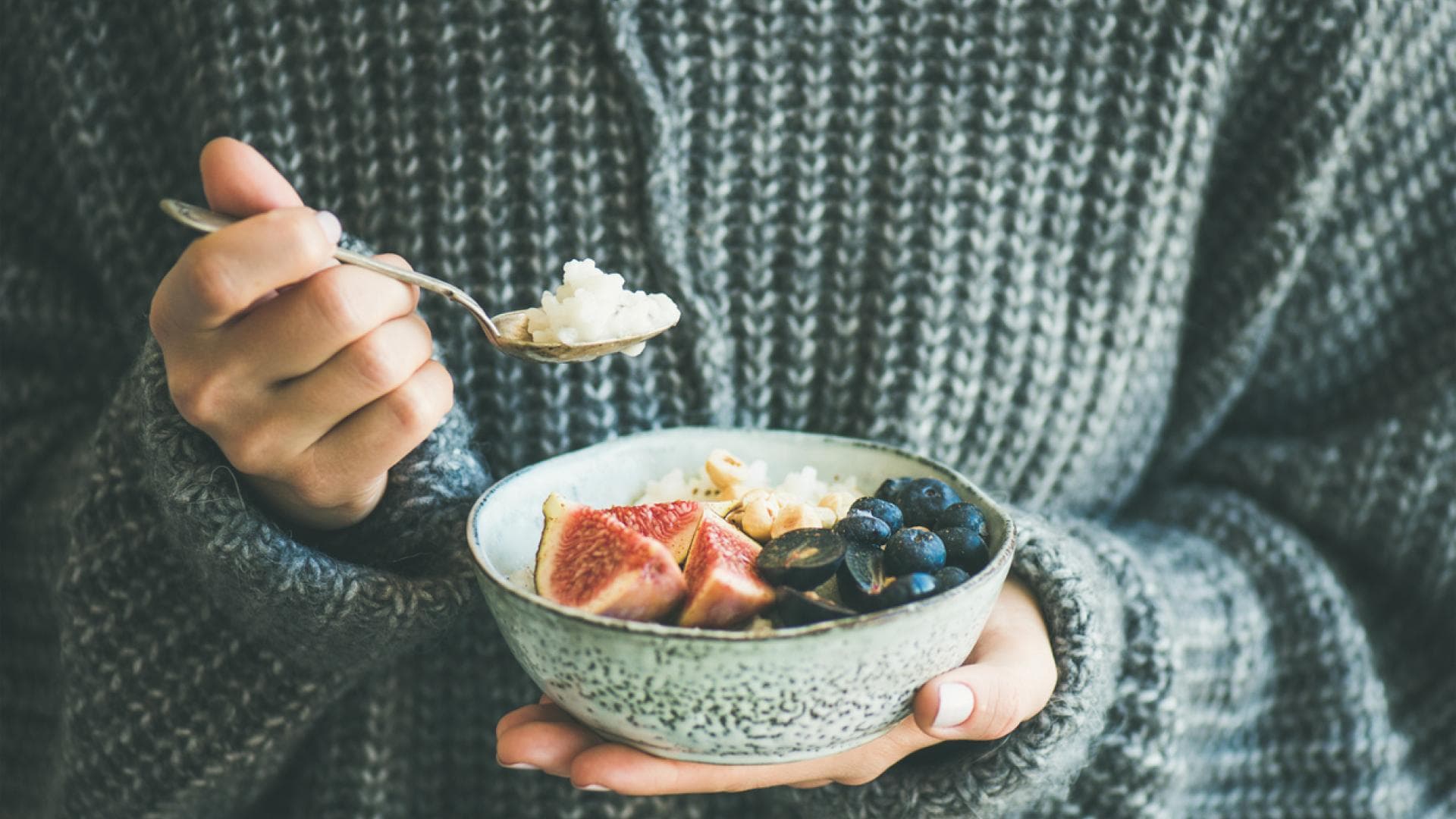 Frau isst Porridge im WInter