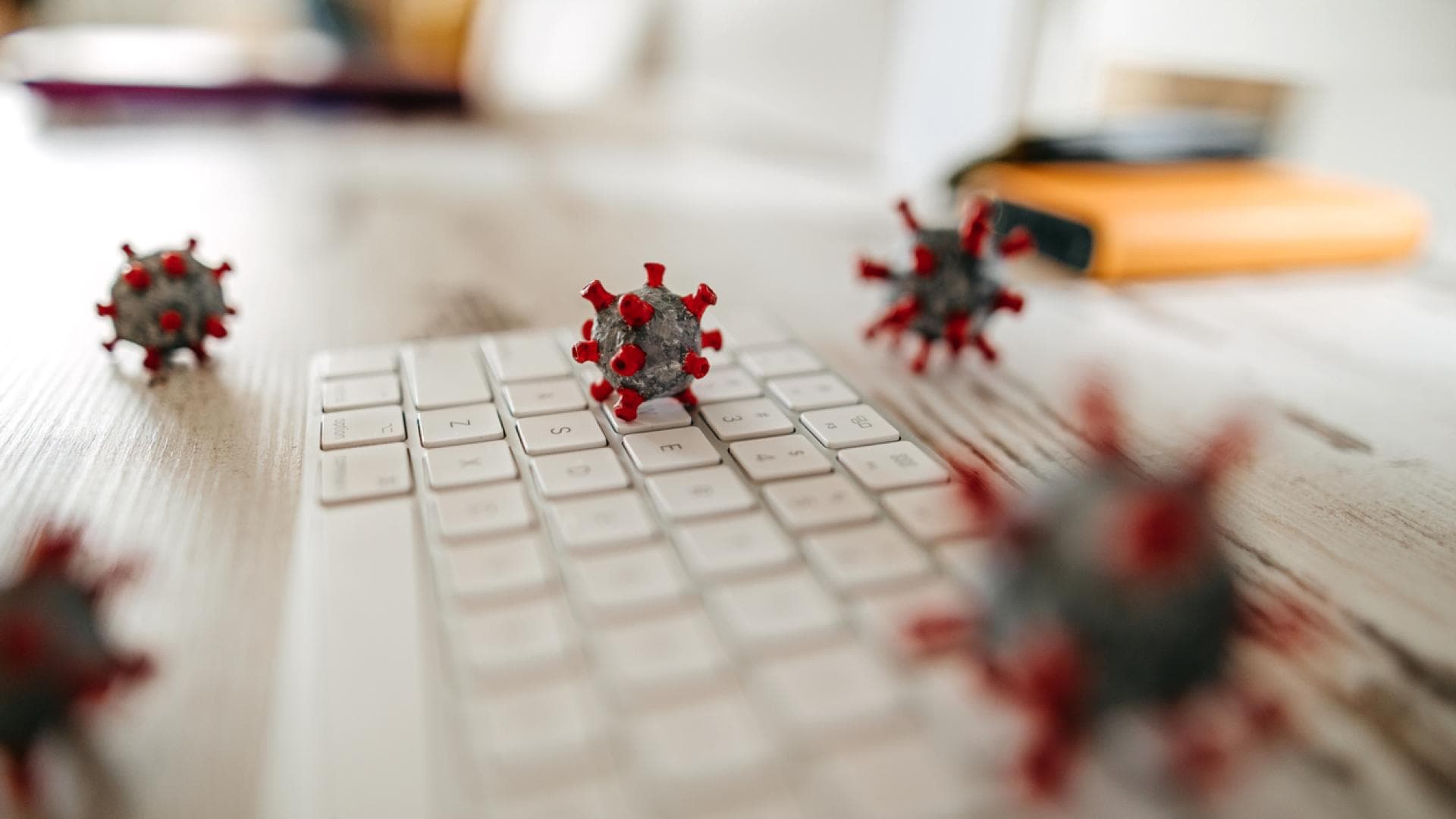 Modelle von Keimen liegen auf einer Tastatur