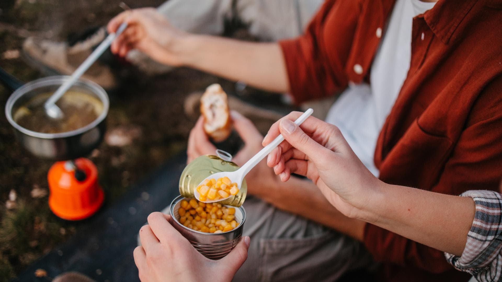 Menschen essen beim Campen aus der Dose