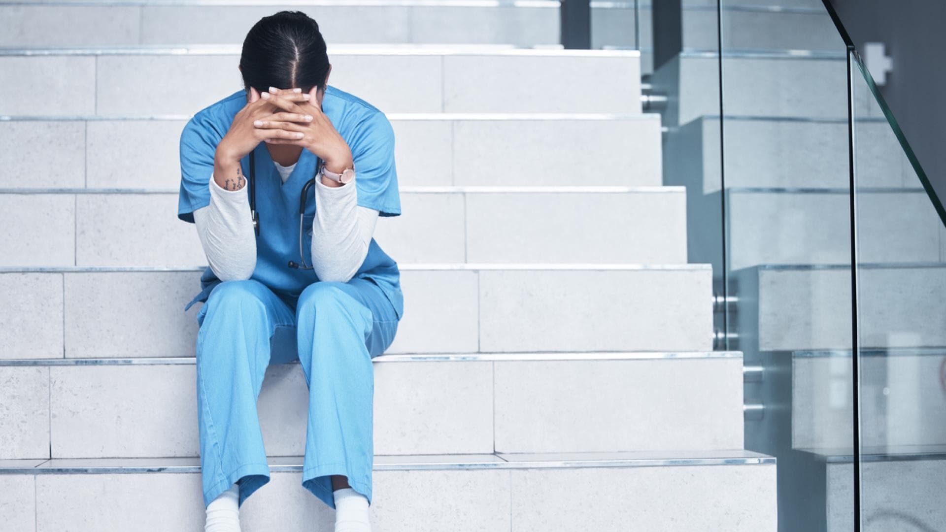 Ausgebrannte Ärztin sitzt auf Krankenhausstufen