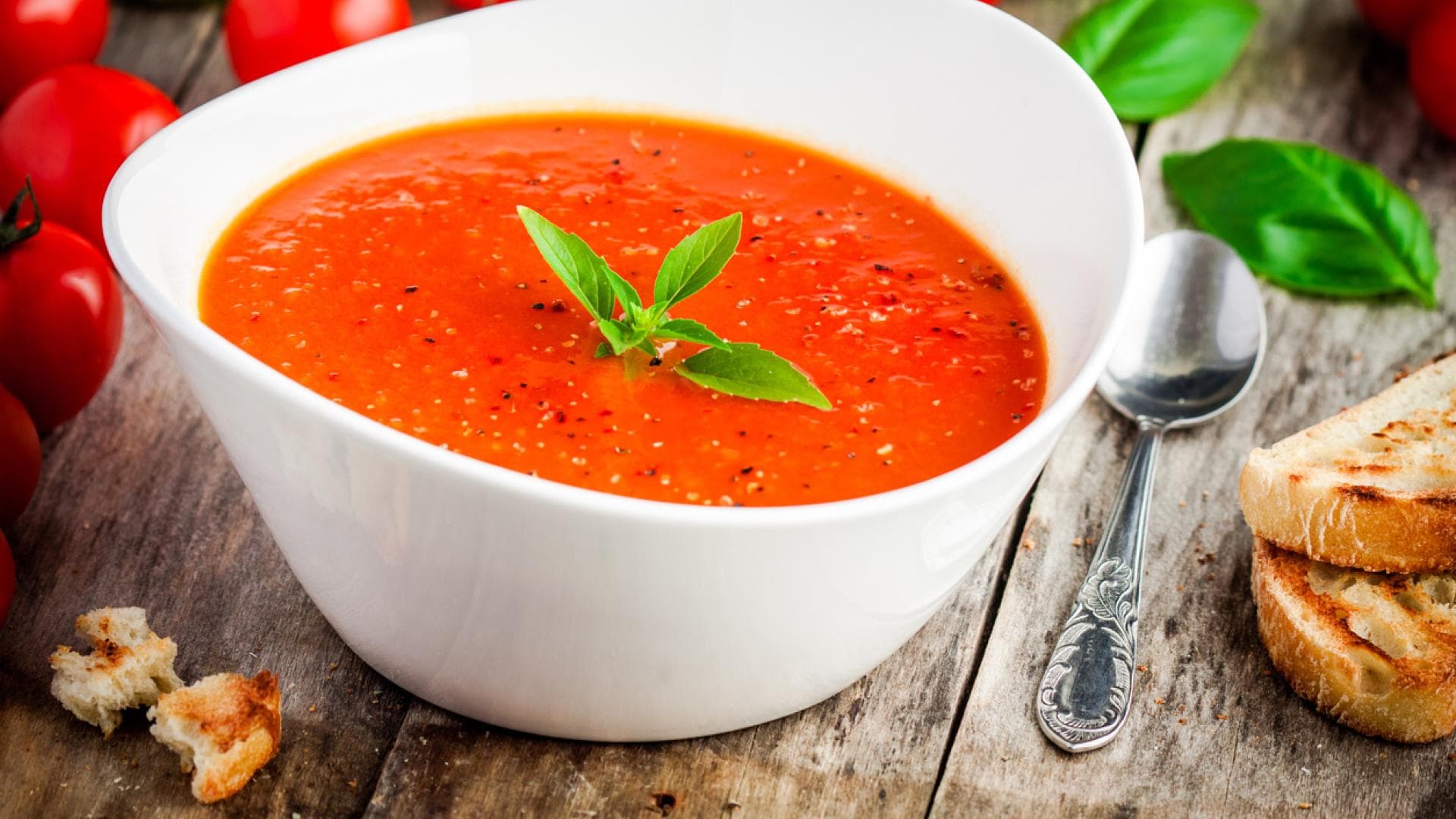 Tomatensuppe in Schüssel auf Holztisch