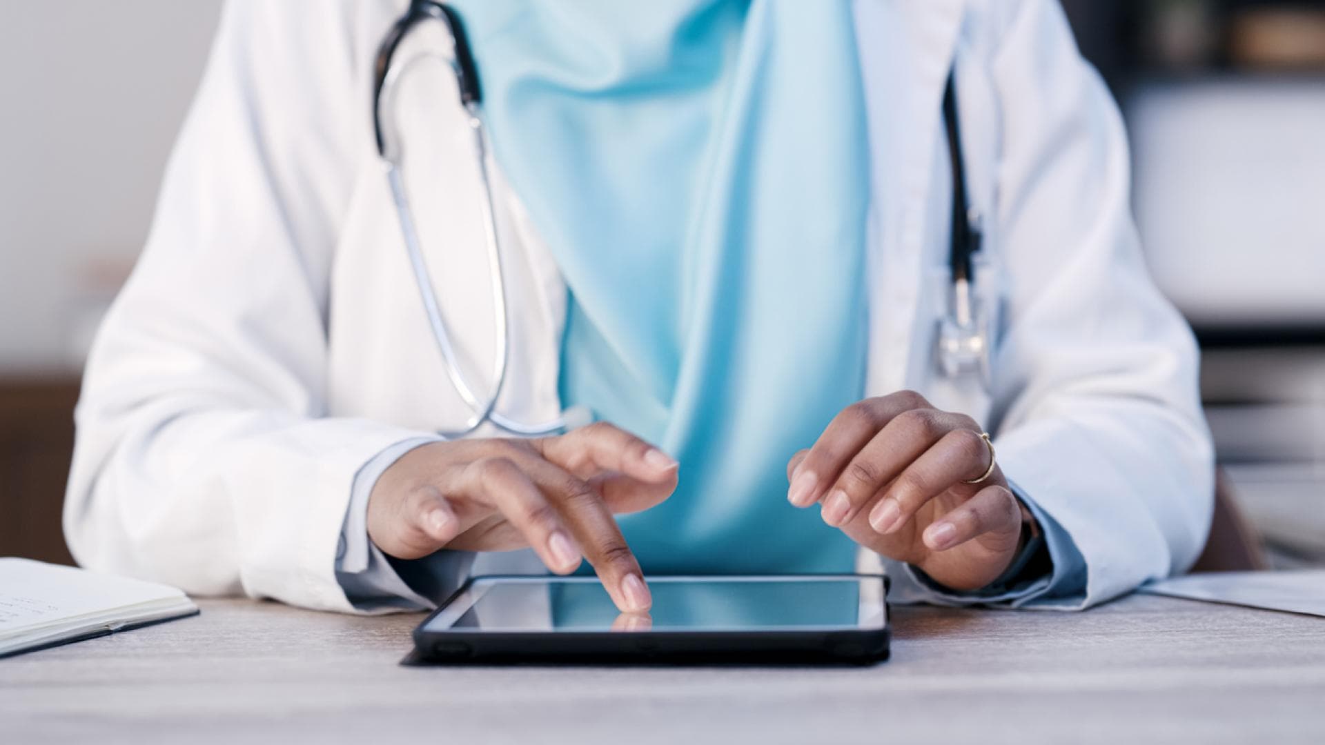 Ärztin nutzt Tablet zur Patientendatenübertragung