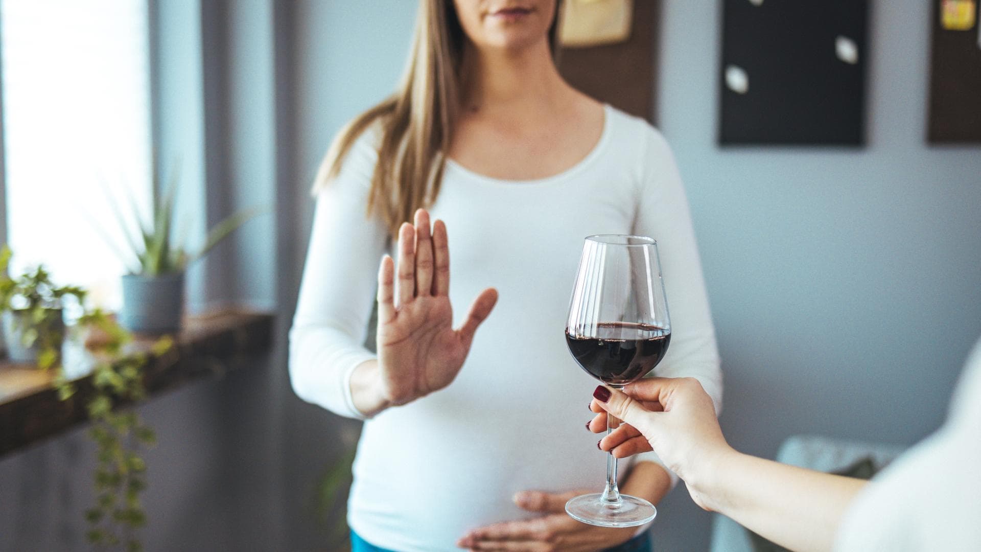 Frau lehnt Glas Rotwein ab