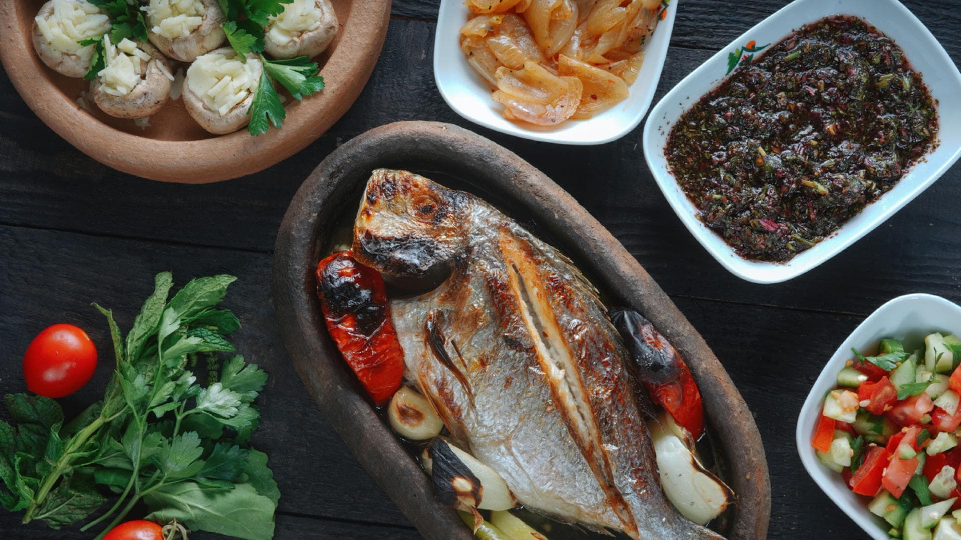 Gegrillter Fisch mit Salat und mediterranen Beilagen