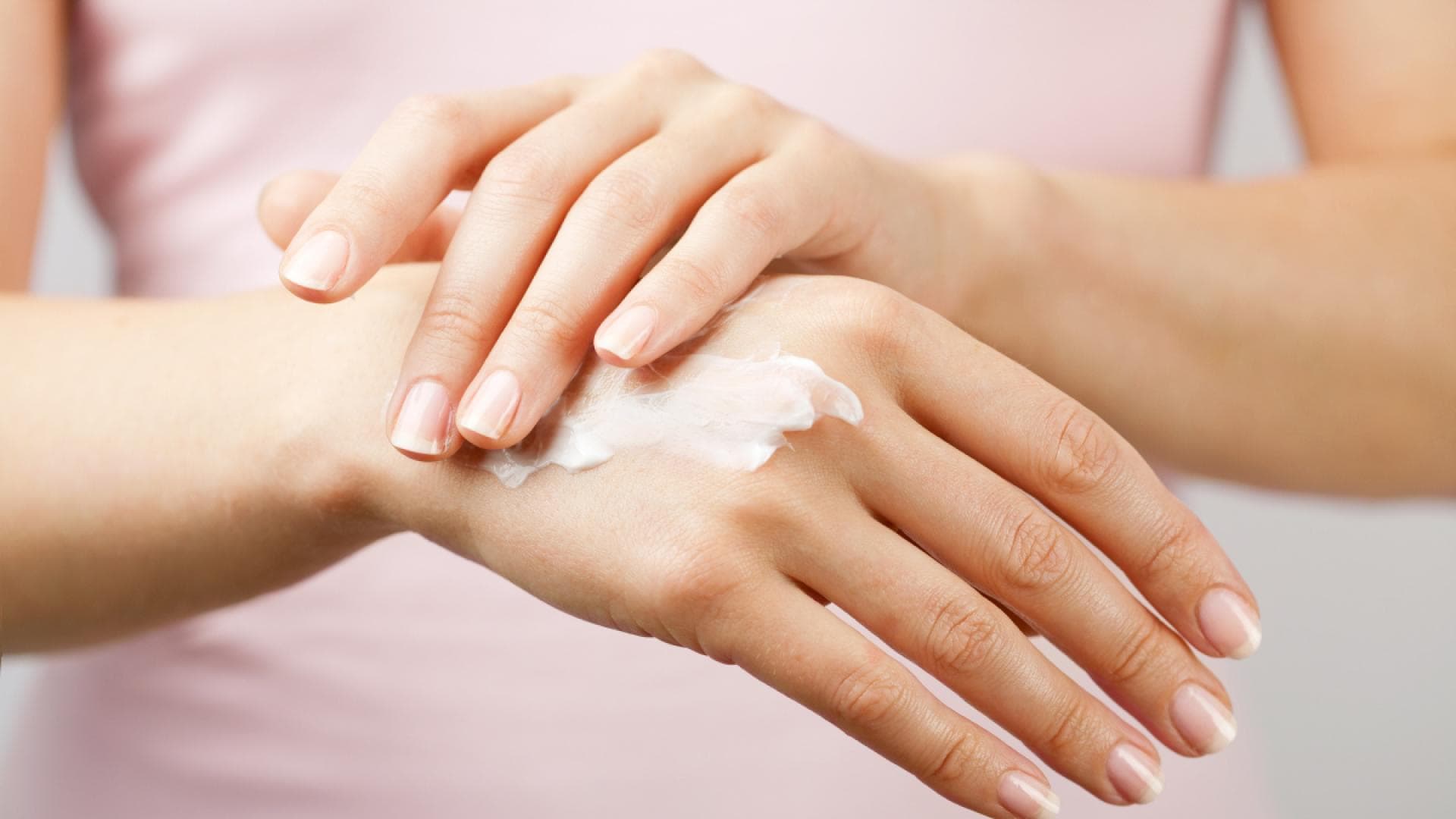 DIY-Handcreme aus nur wenigen Zutaten Frau cremt sich Handrücken ein