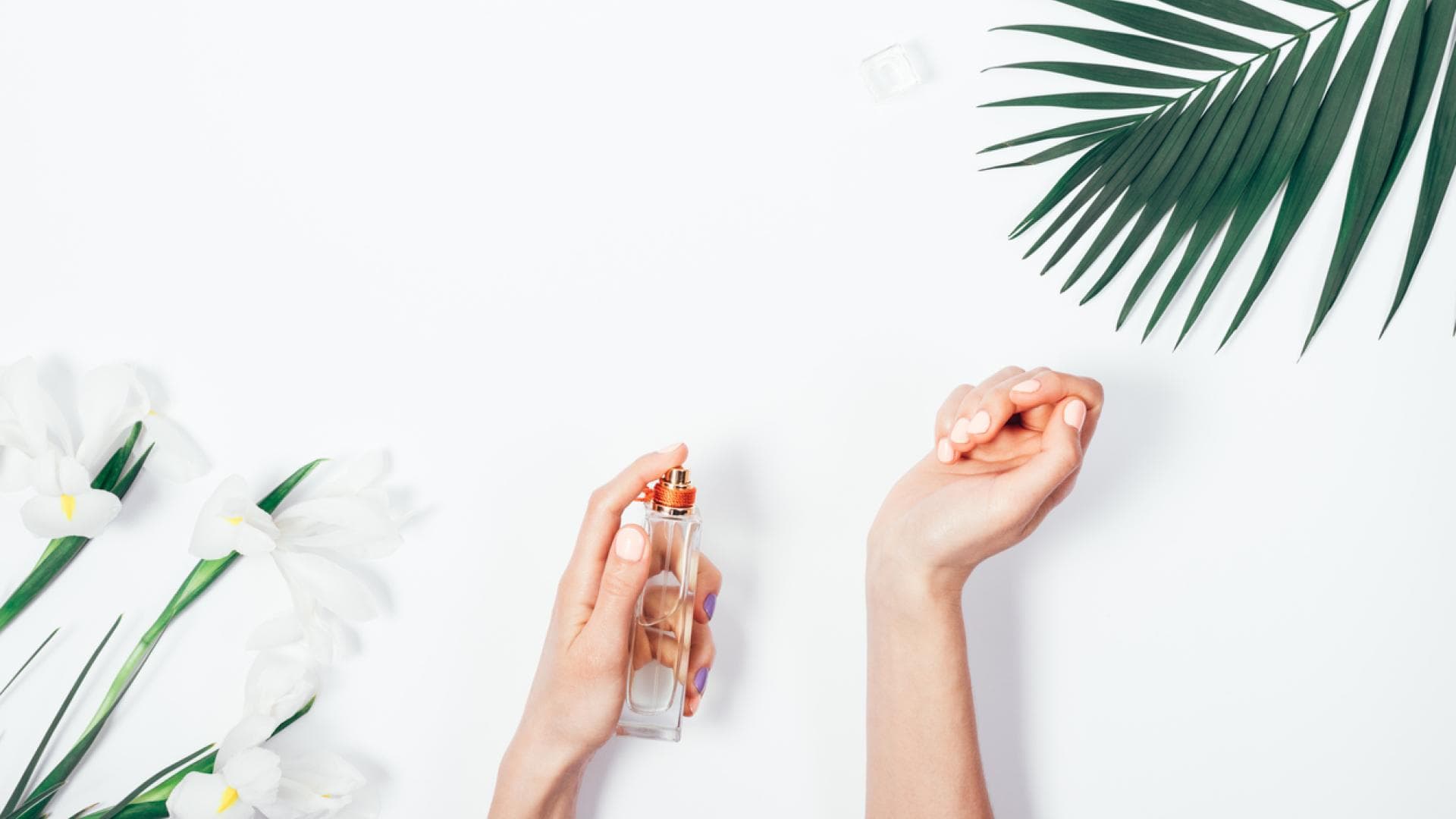 Frau sprüht Parfum auf das Handgelenk