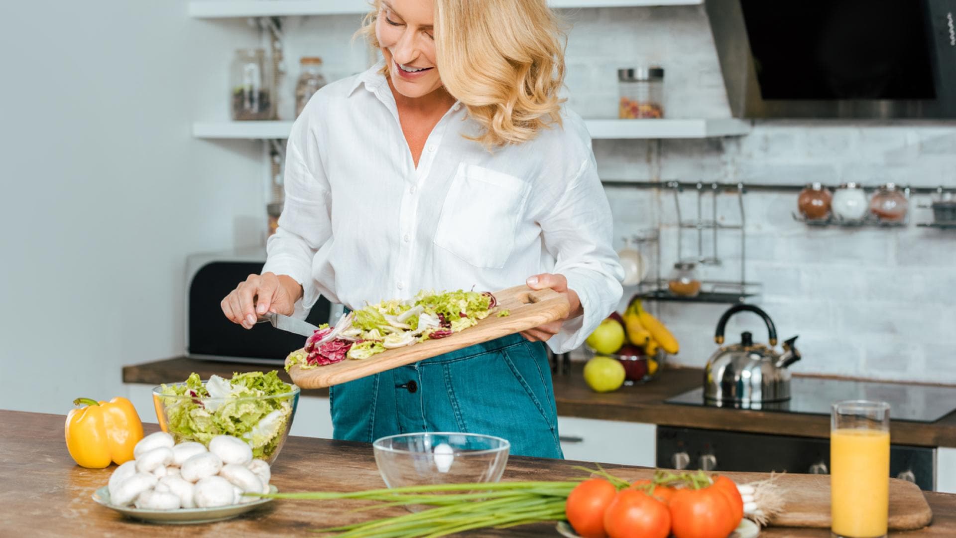 Frau schneidet Salat selbst