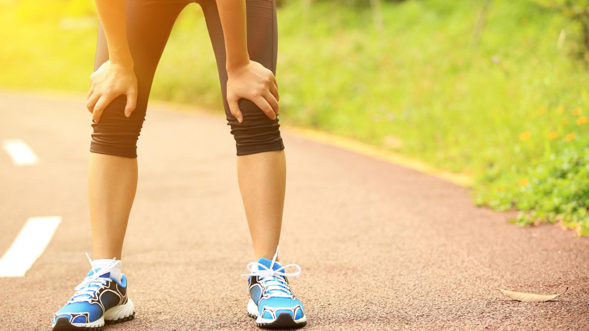 Joggerin stützt sich auf Knien ab