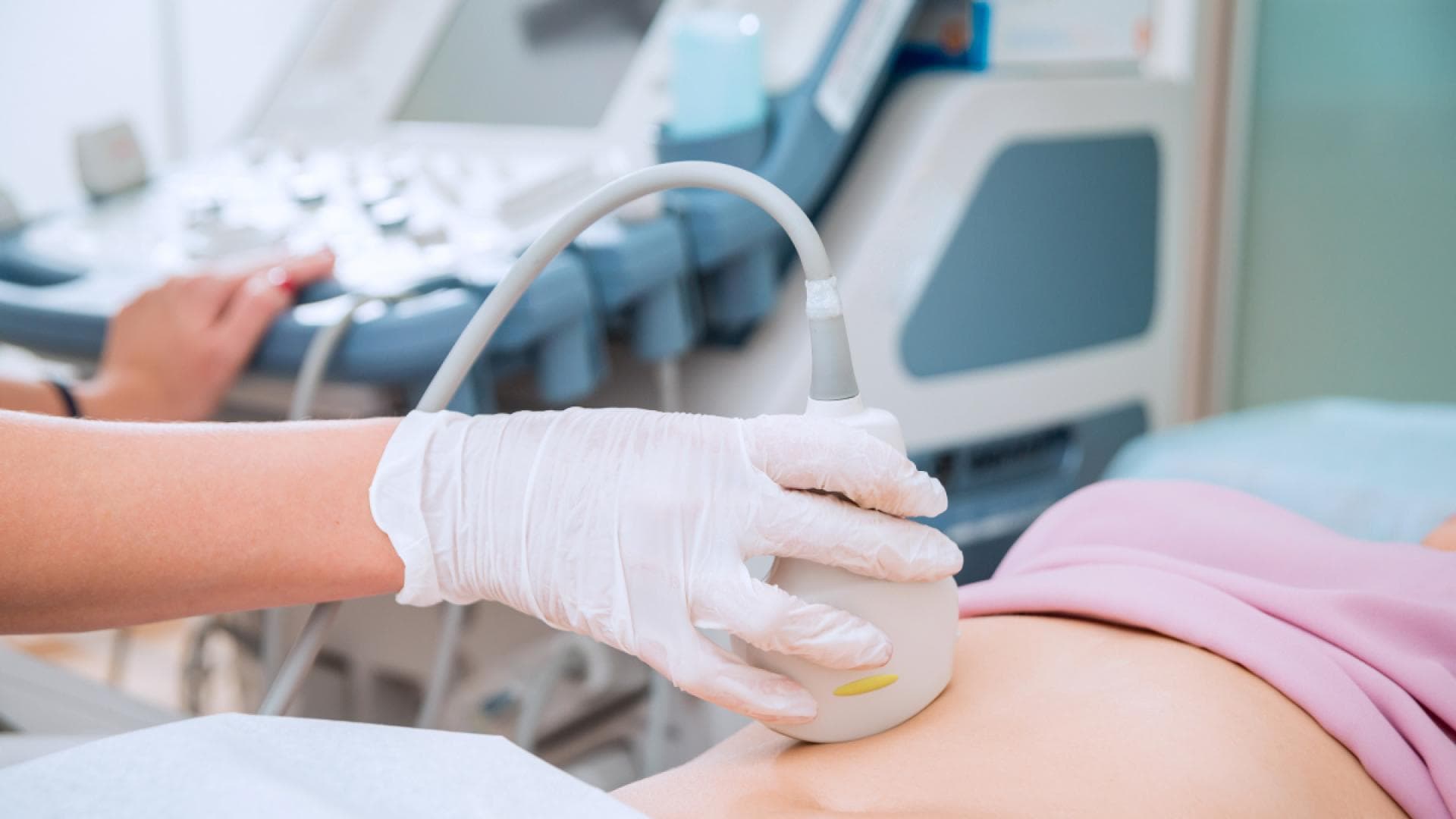 Ärztin untersucht Bauch einer Patientin mit Ultraschall