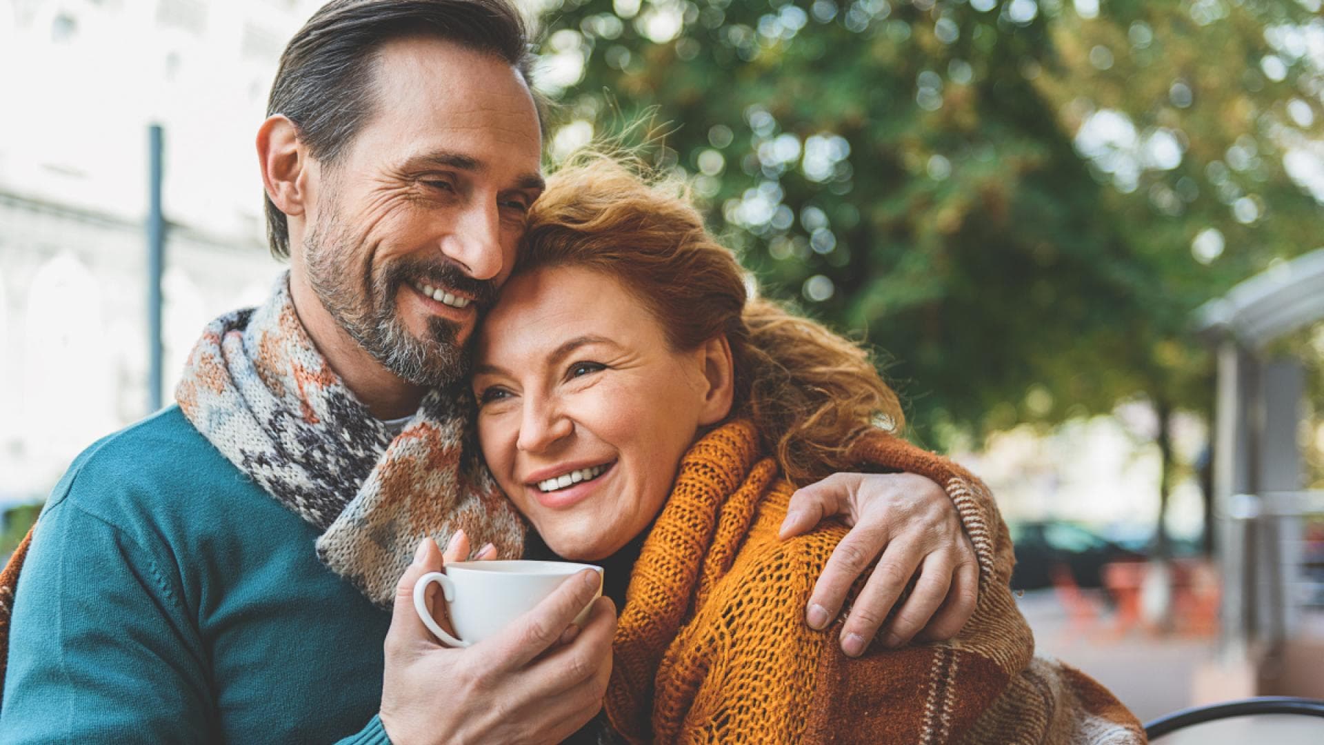 Mann und Frau halten sich im Café im Arm