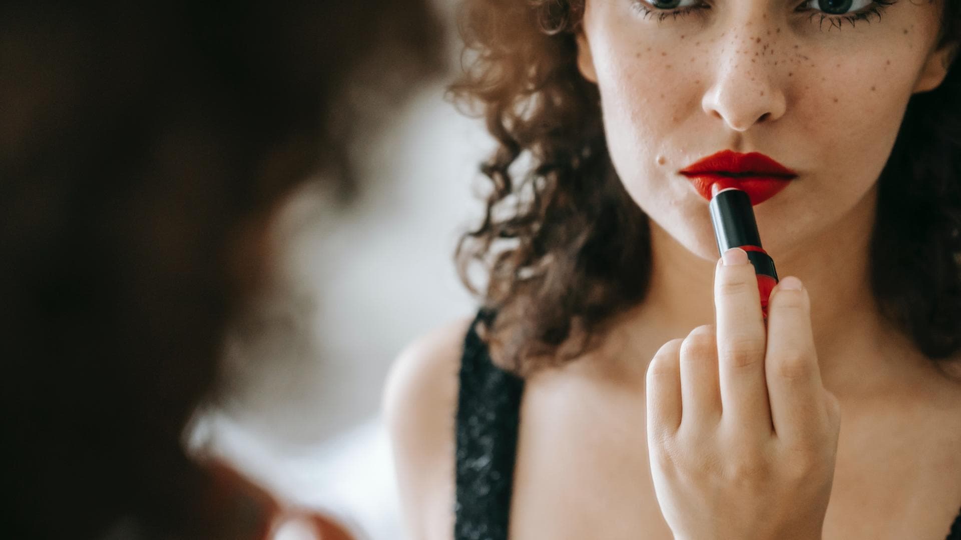 Frau trägt Lippenstift auf