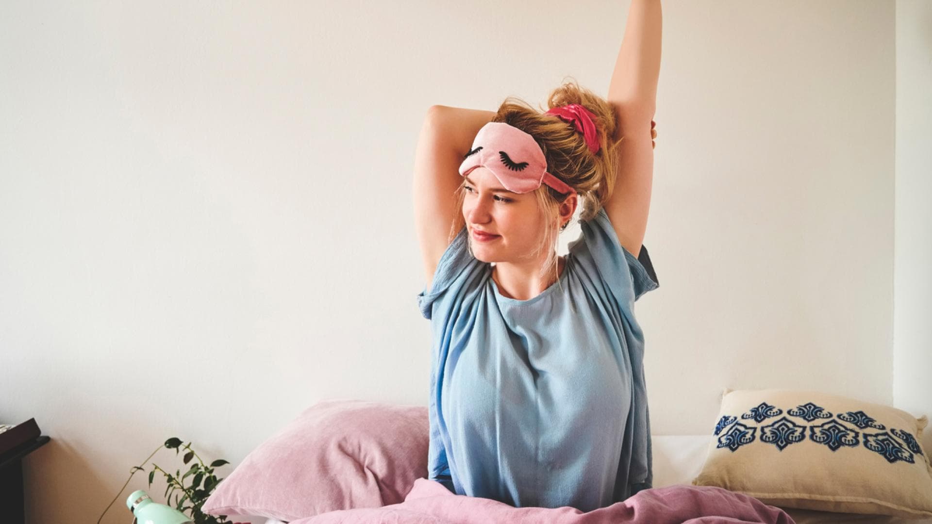 Frau streckt sich im Bett