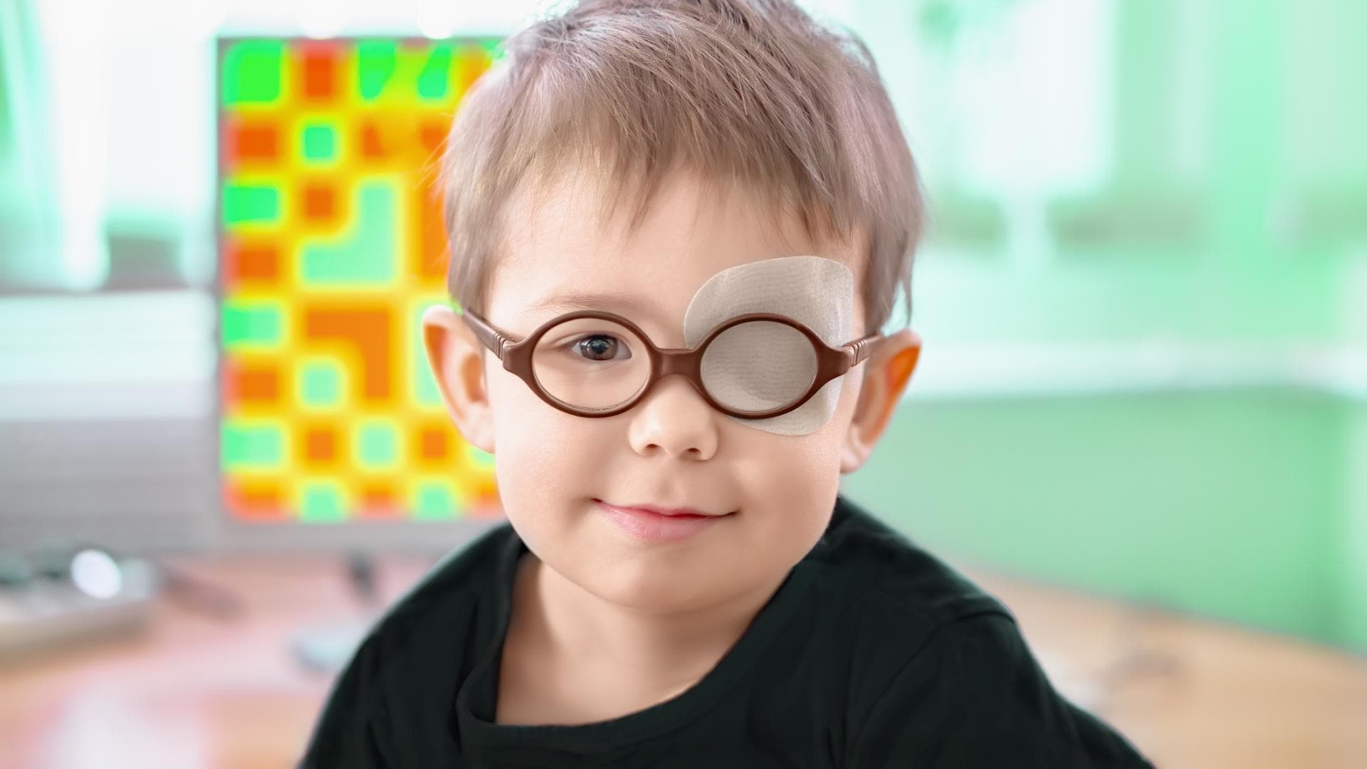Ein kleiner Junge mit Brille und Augenklappe