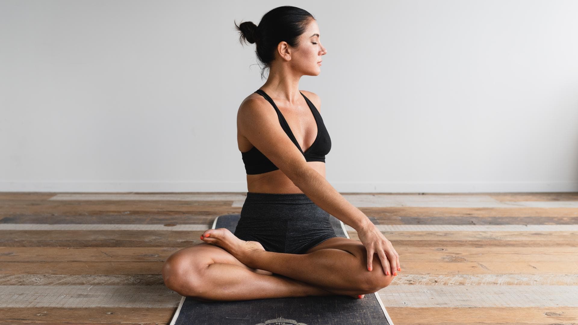 Frau auf Matte macht Yoga