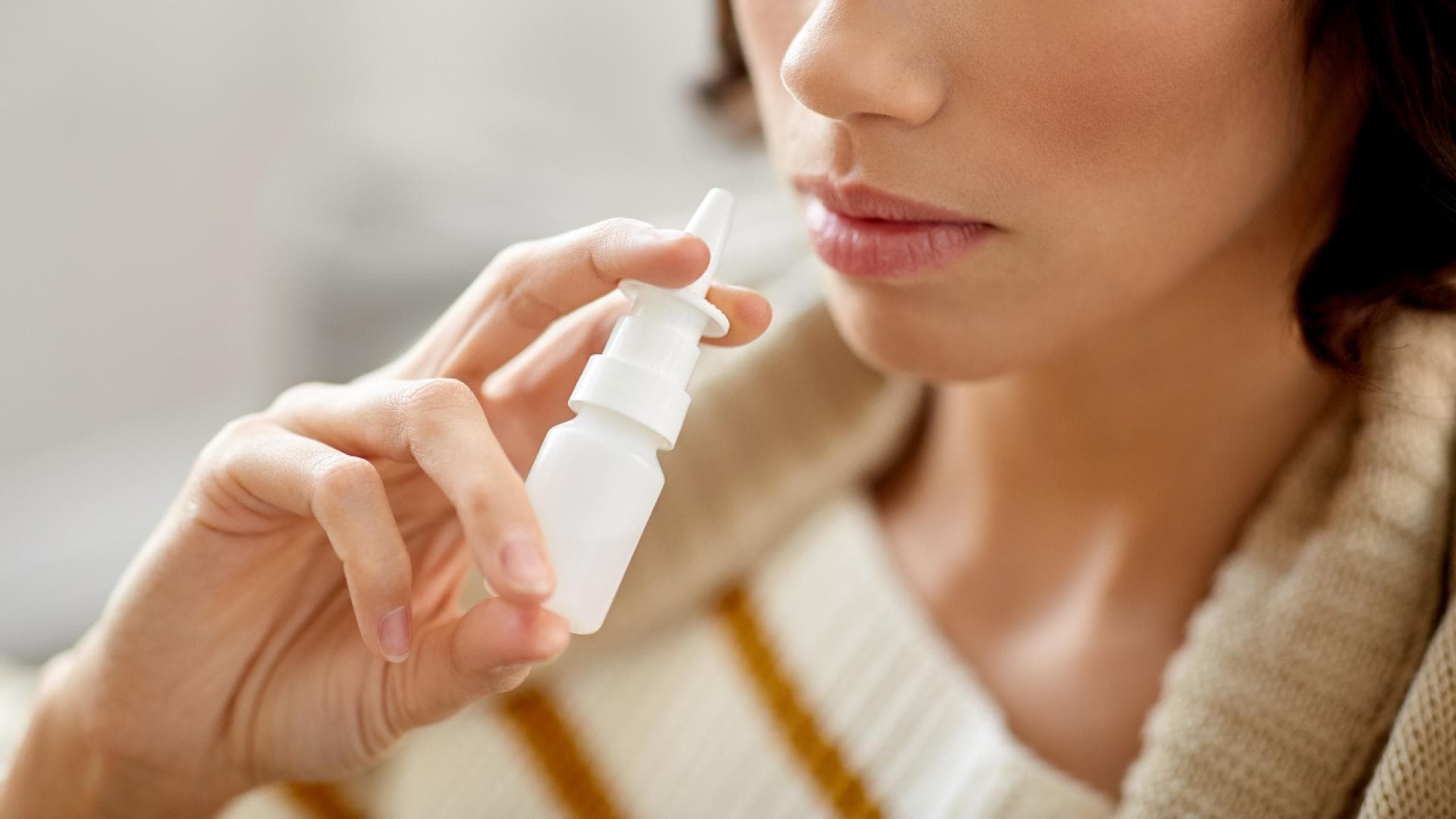 Nasenspray letzte Hilfe bei Heuschnupfen Frau mit Nasenspray in der Hand