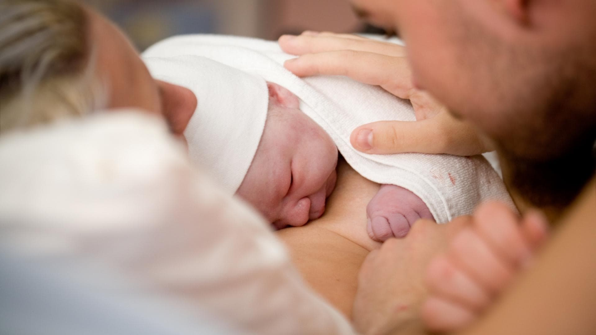 Neugeborenes schläft auf Brust von Mutter