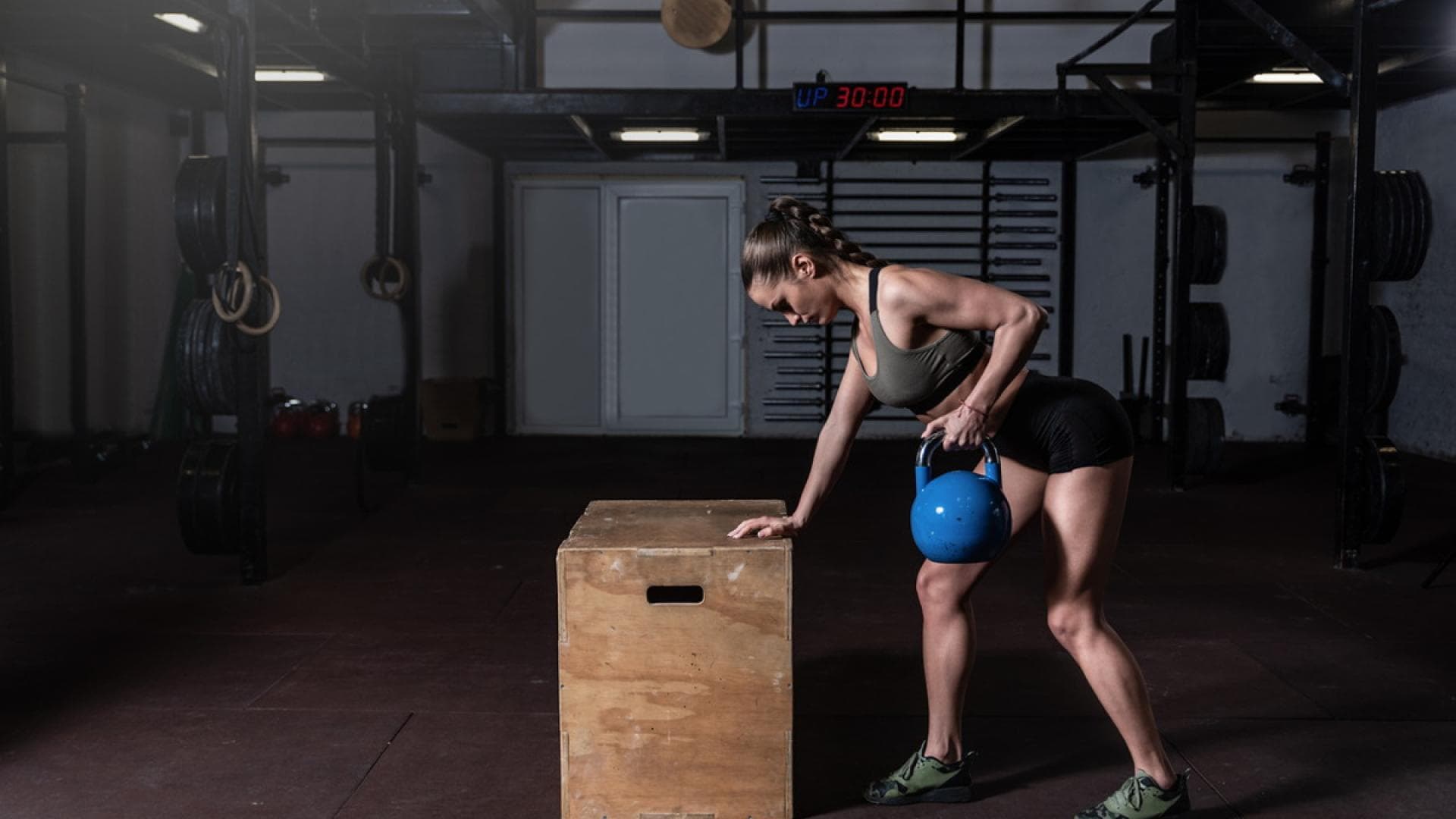 Frau mit Kettlebell macht einarmiges Rudern