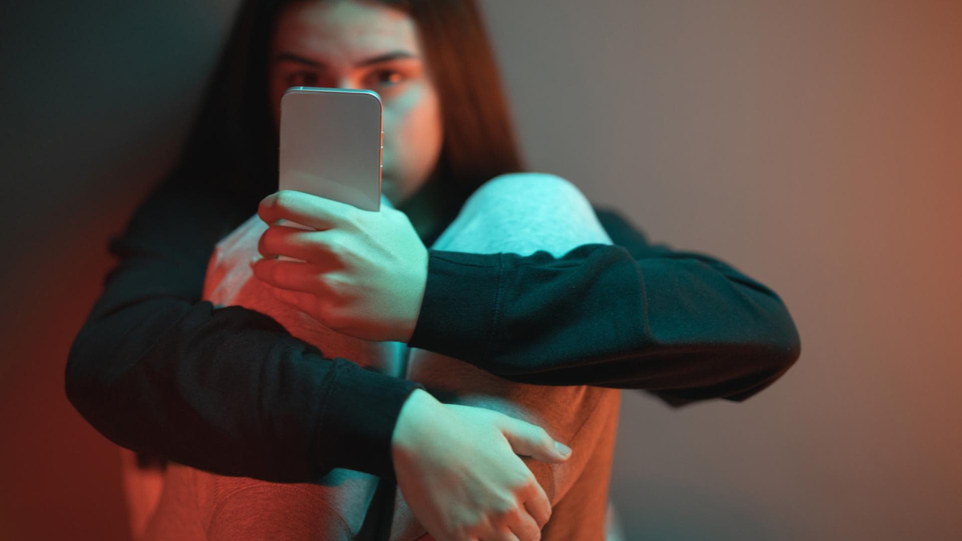Junges Mädchen starrt süchtig auf Handy