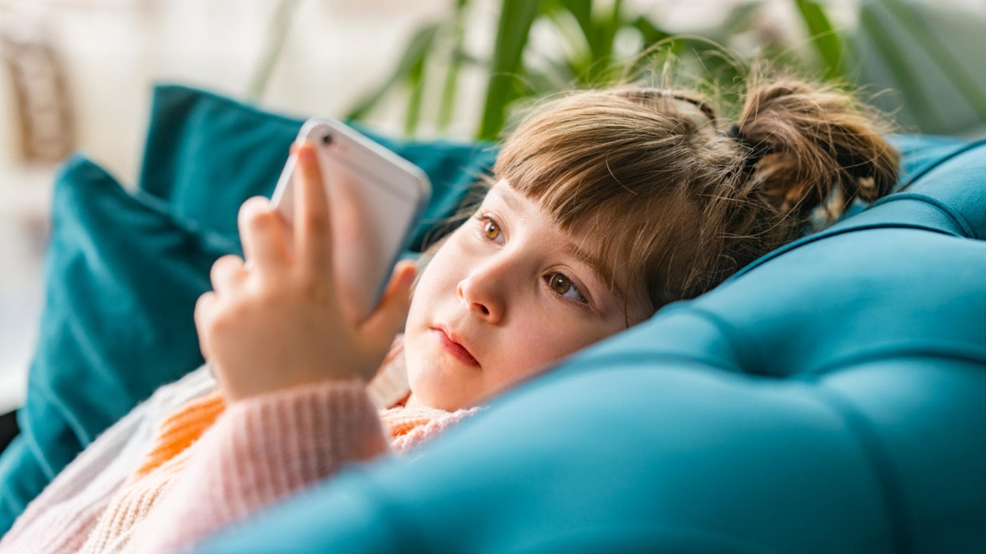Kleines Mädchen starrt auf Handy