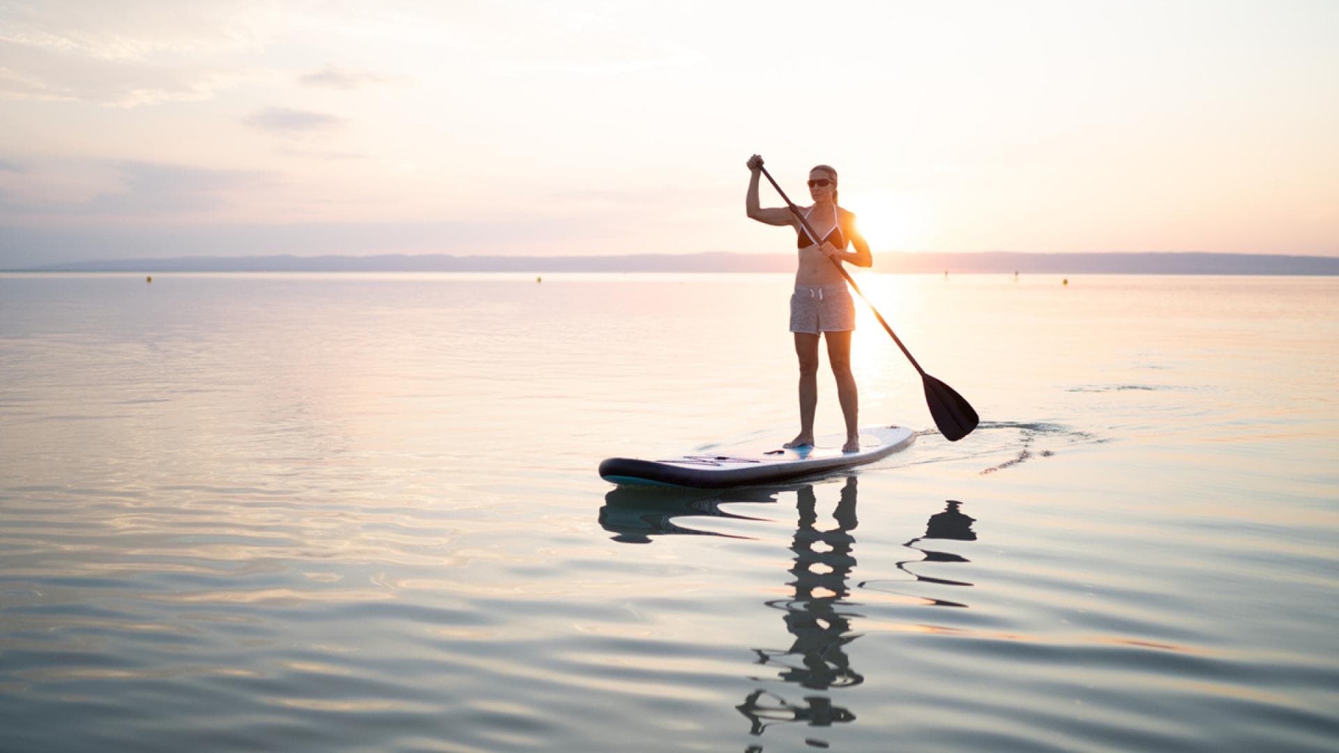 Frau steht auf SUP