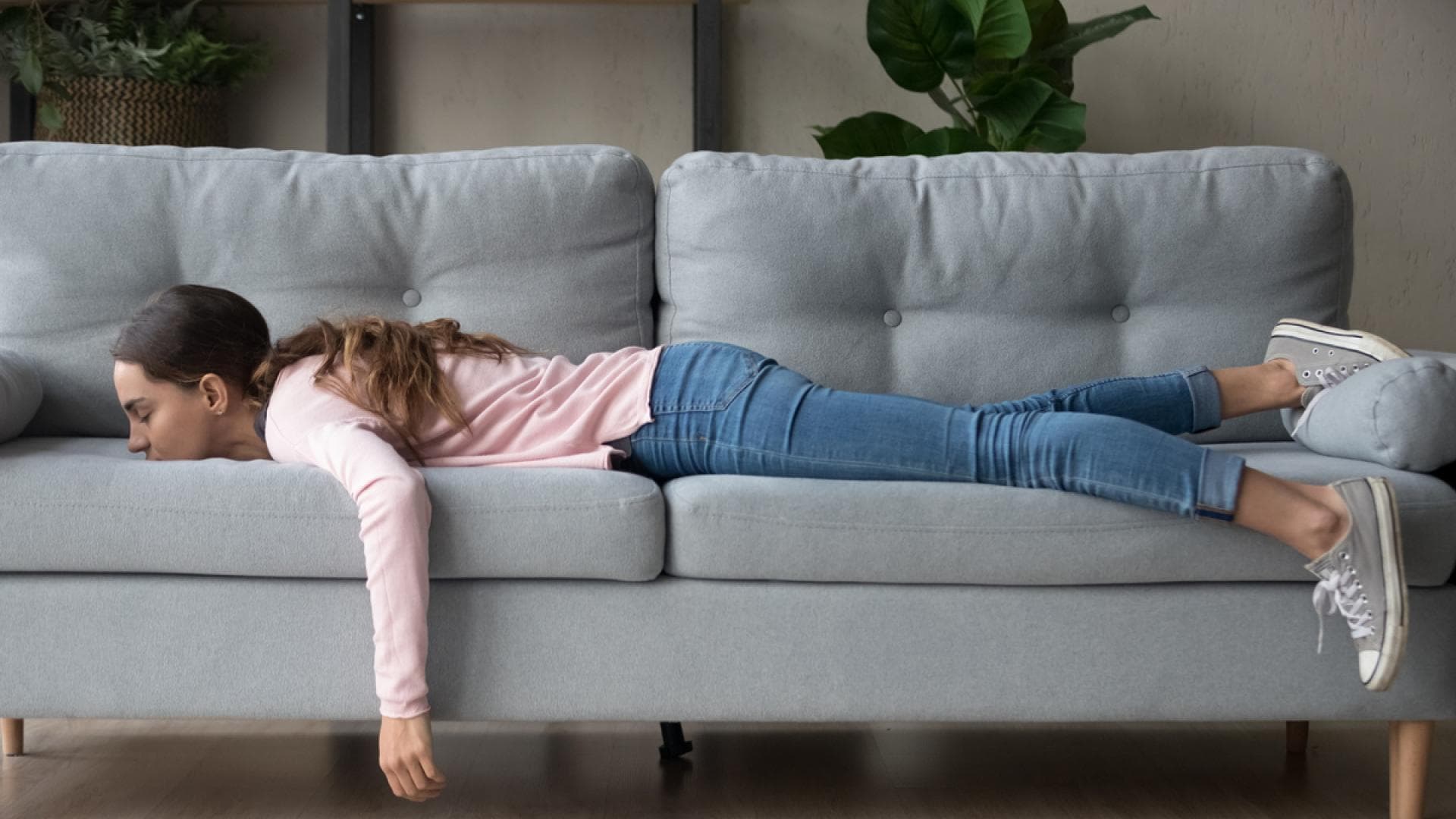 Erschöpfte Frau liegt auf der Couch