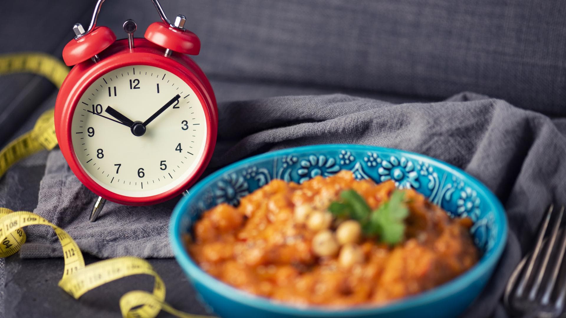 Wecker neben Schale mit Essen