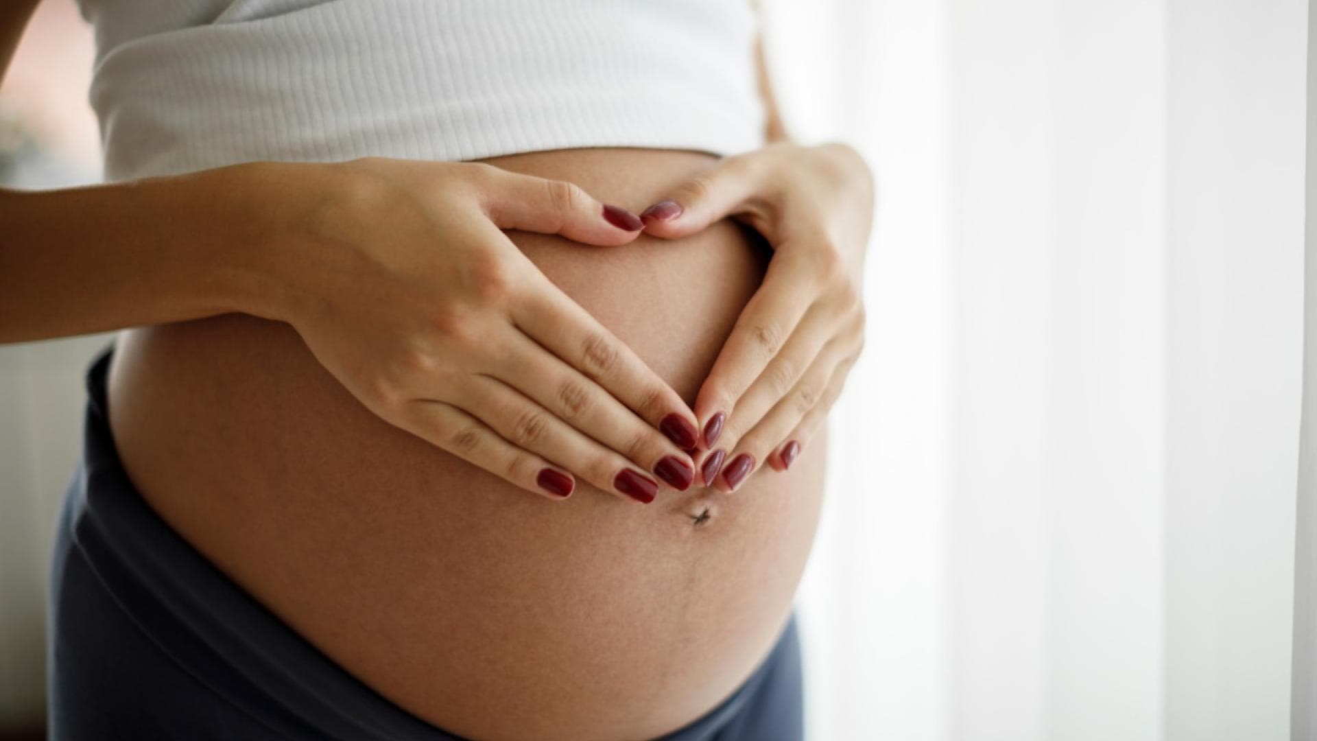 Schwangere Frau hält sich den Bauch