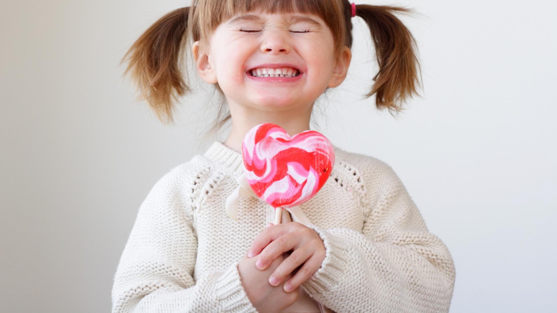 Kleines Mädchen lacht mit Riesenlolli