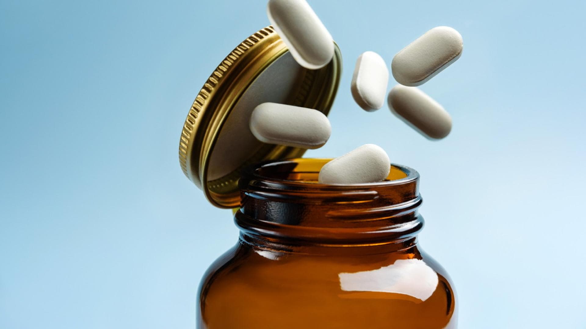 Tabletten fallen aus einer Glasflasche