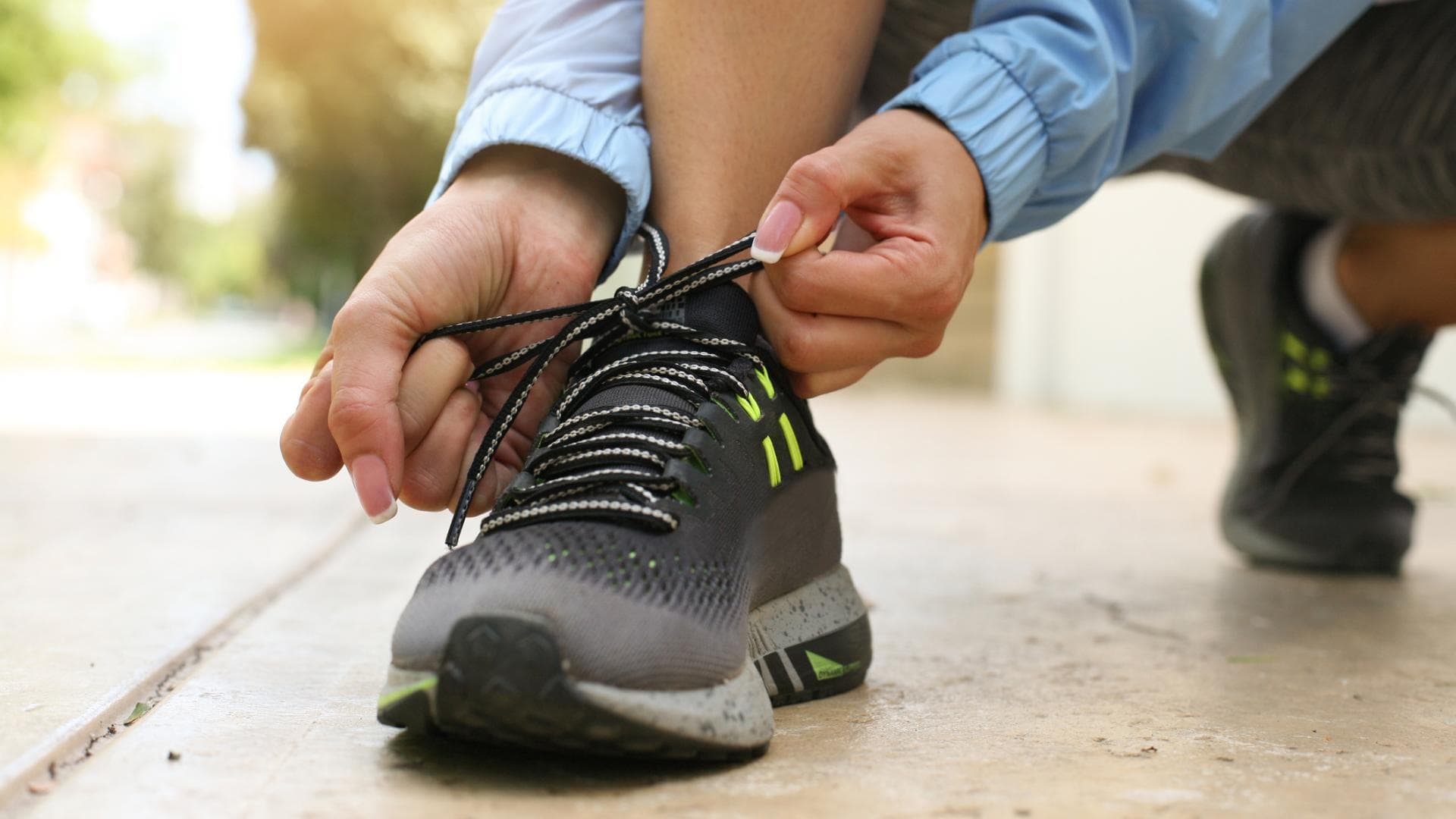 Frau bindet sich Sportschuhe zu Frau bindet sich Sportschuhe zu