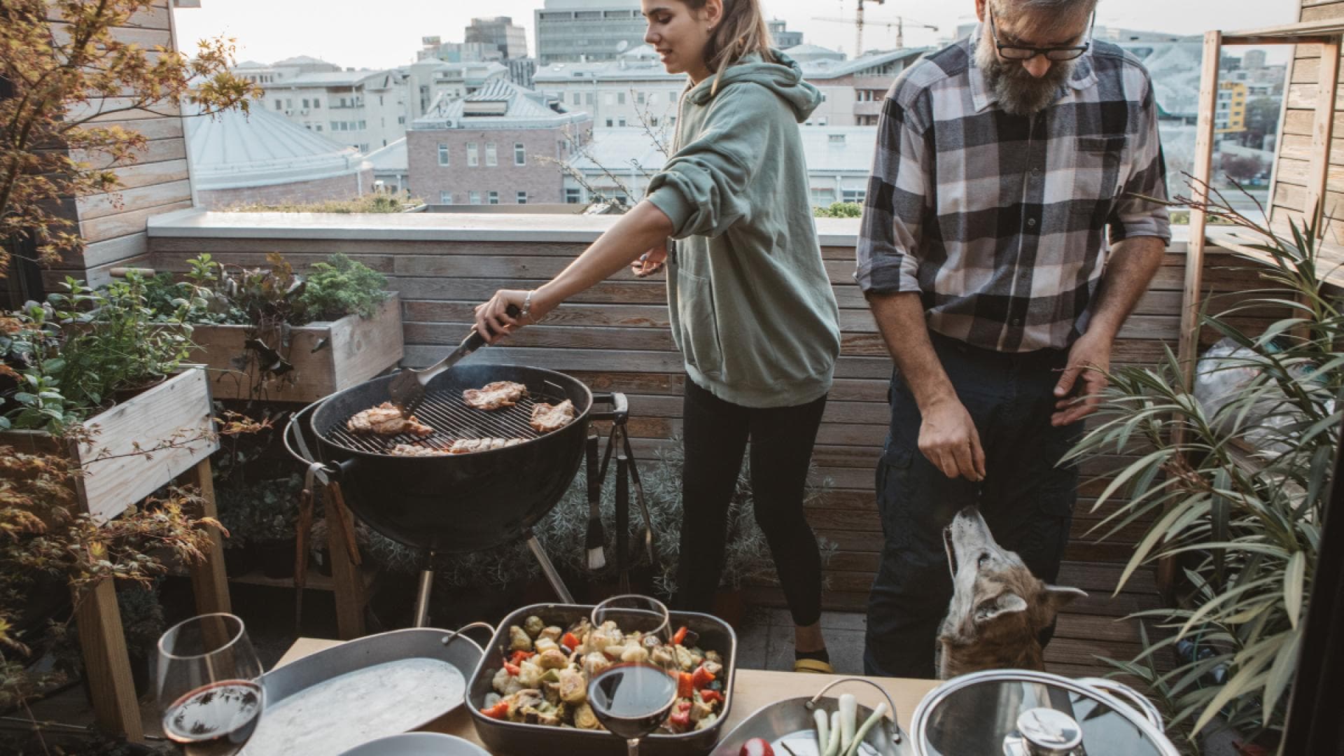 Mann und Frau grillen auf Balkon