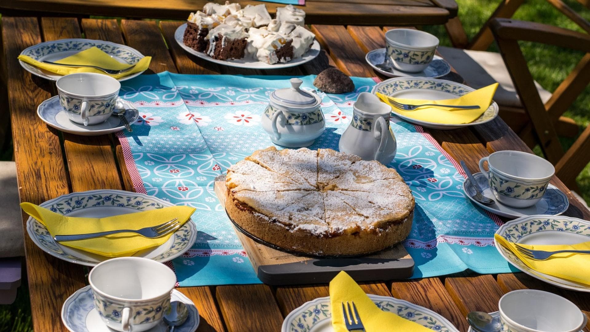 Gemeinsam mit geliebten Menschen Kuchen zu essen, entschleunigt den Alltag und bringt sofort wohlige Gefühle. Kuchentafel im Garten