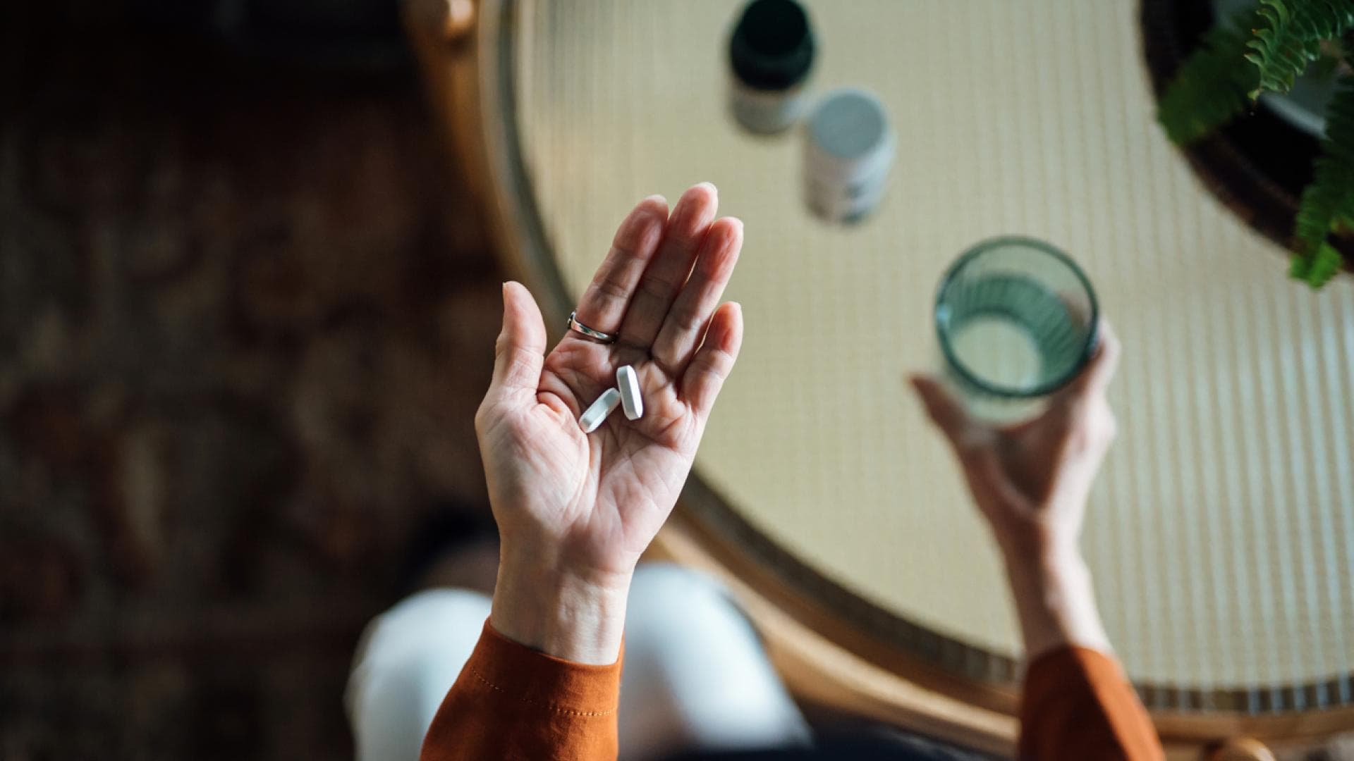 Frau hält Vitaminpräparate in der Hand