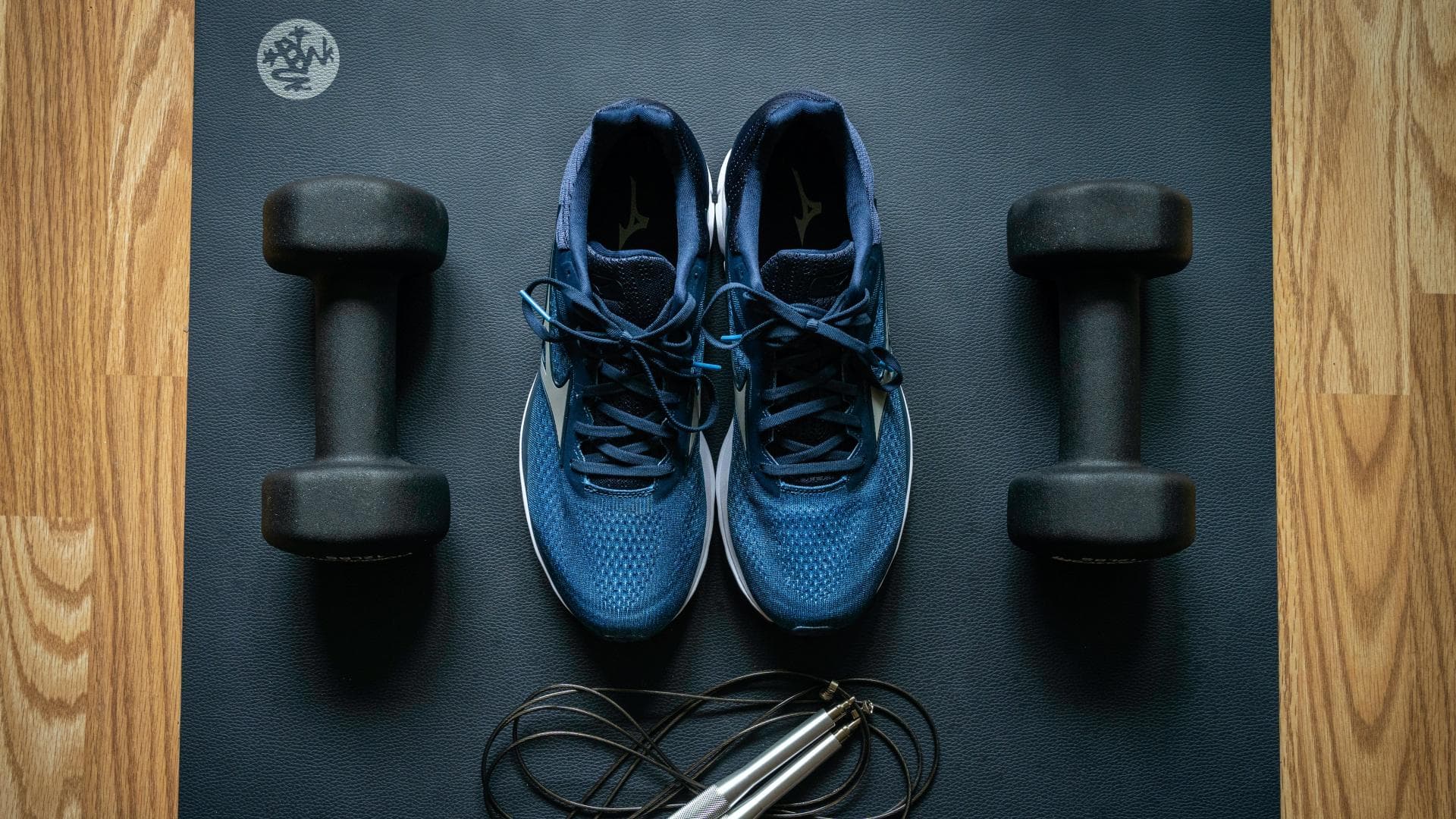 Sportschuhe und Hanteln auf Yoga-Matte
