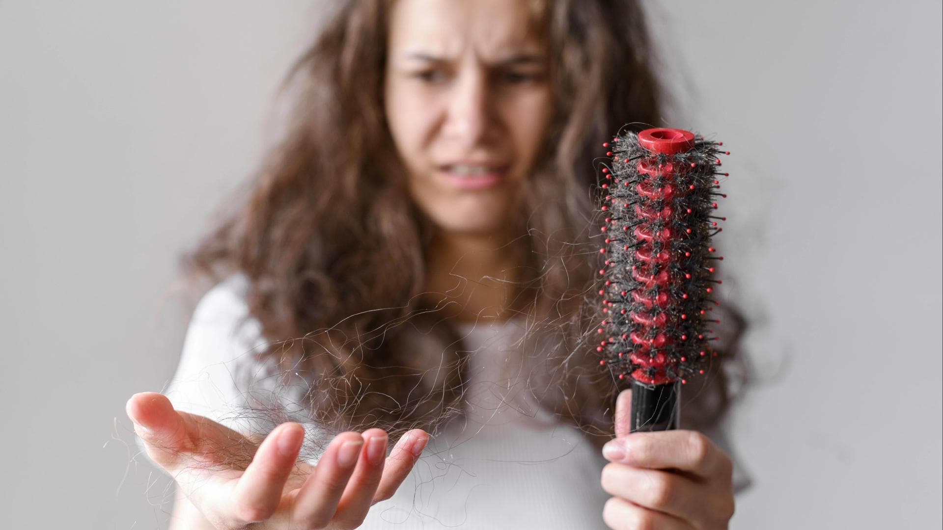 Frau hält ausfallende Haare in den Händen