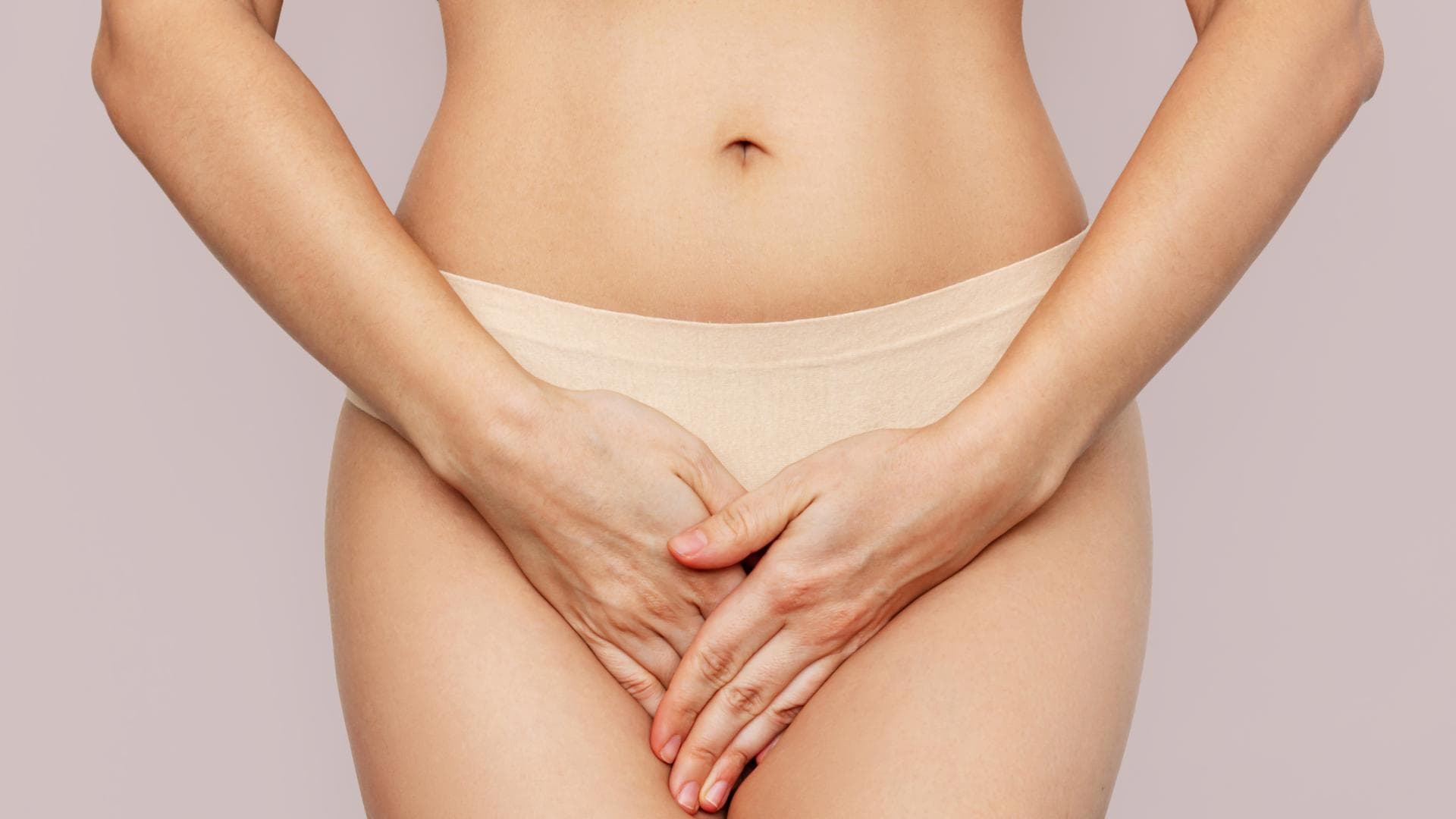 Frau hält die Hände vor ihren Intimbereich
