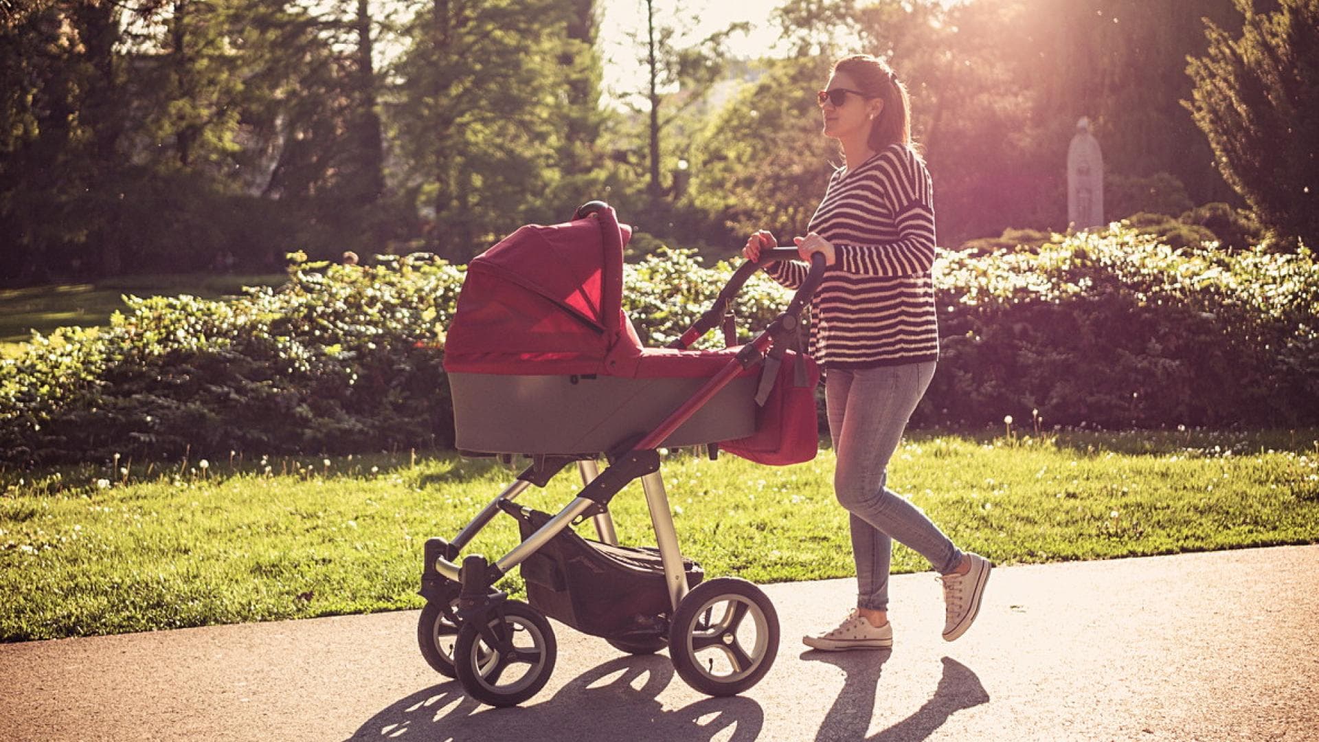 Mutter schiebt Kind im Kinderwagen