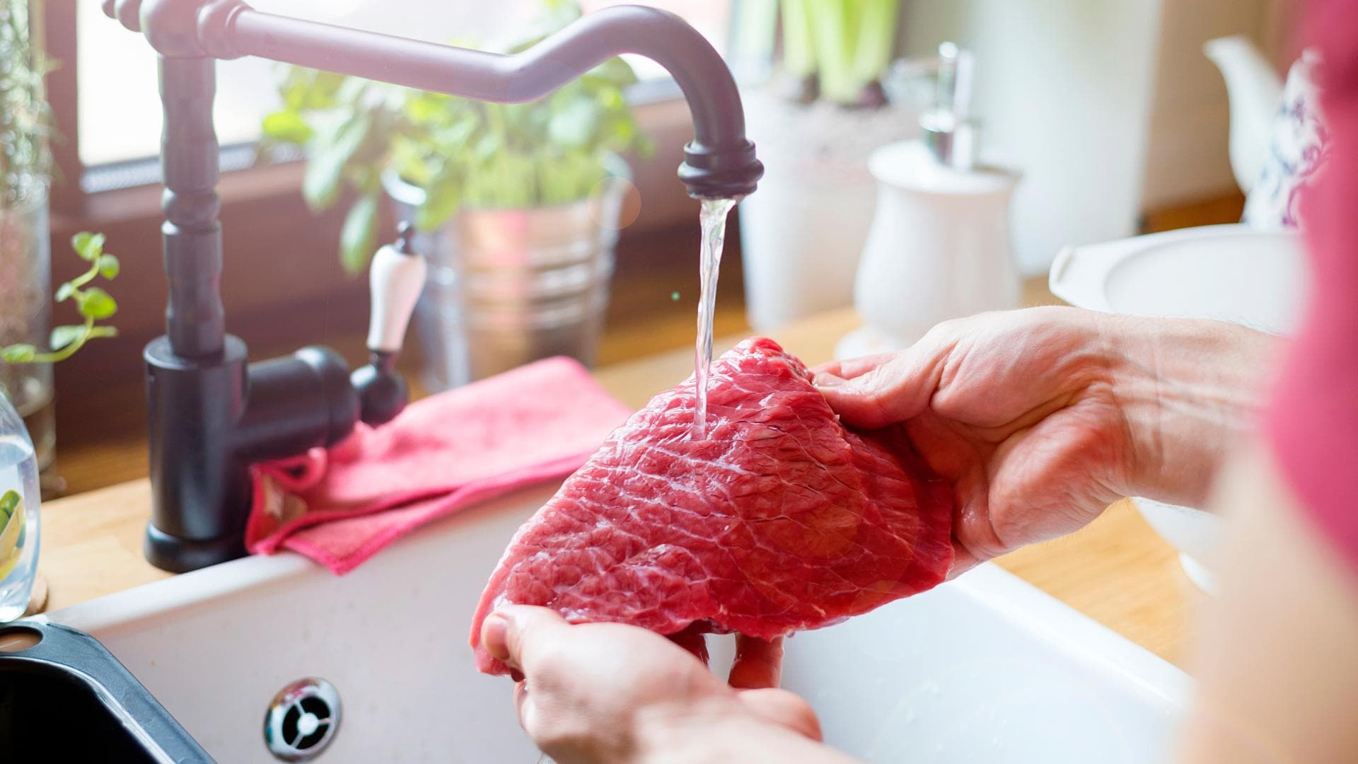 Mann wäscht rohes Steak