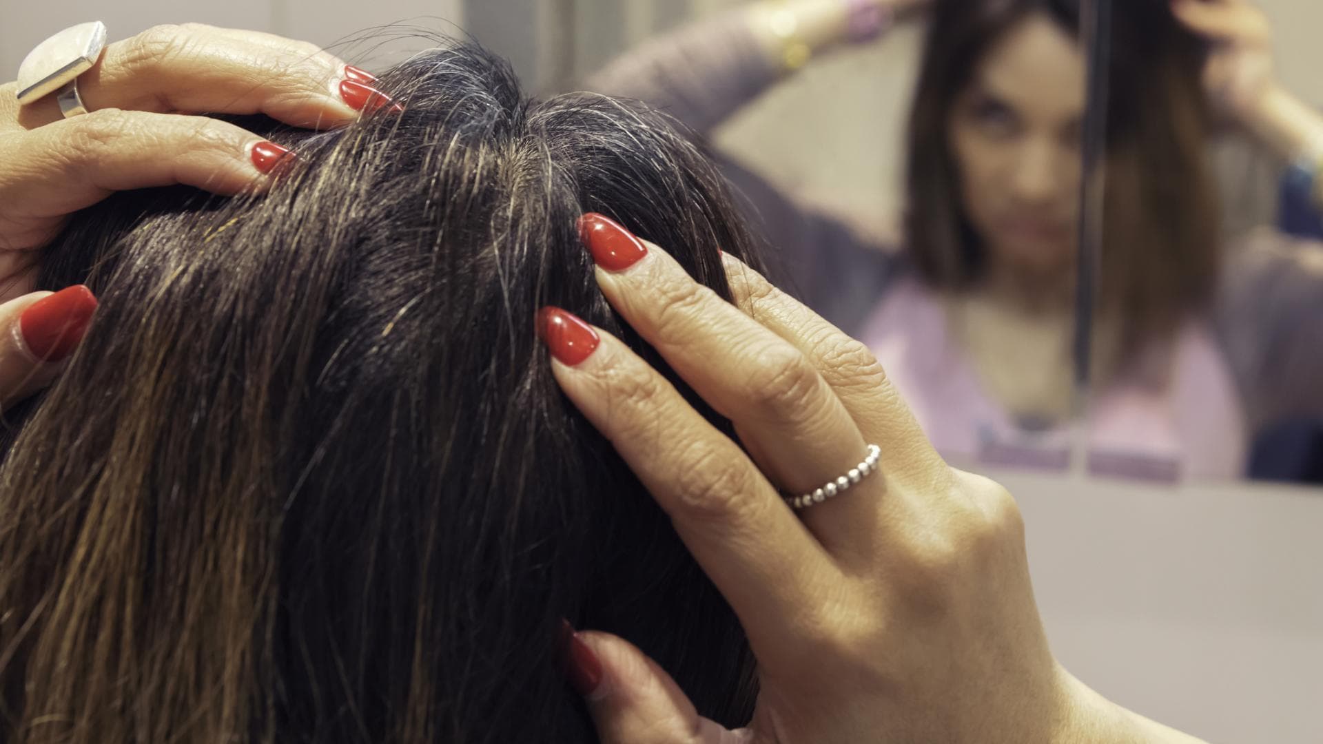 Frau entdeckt graue Haare