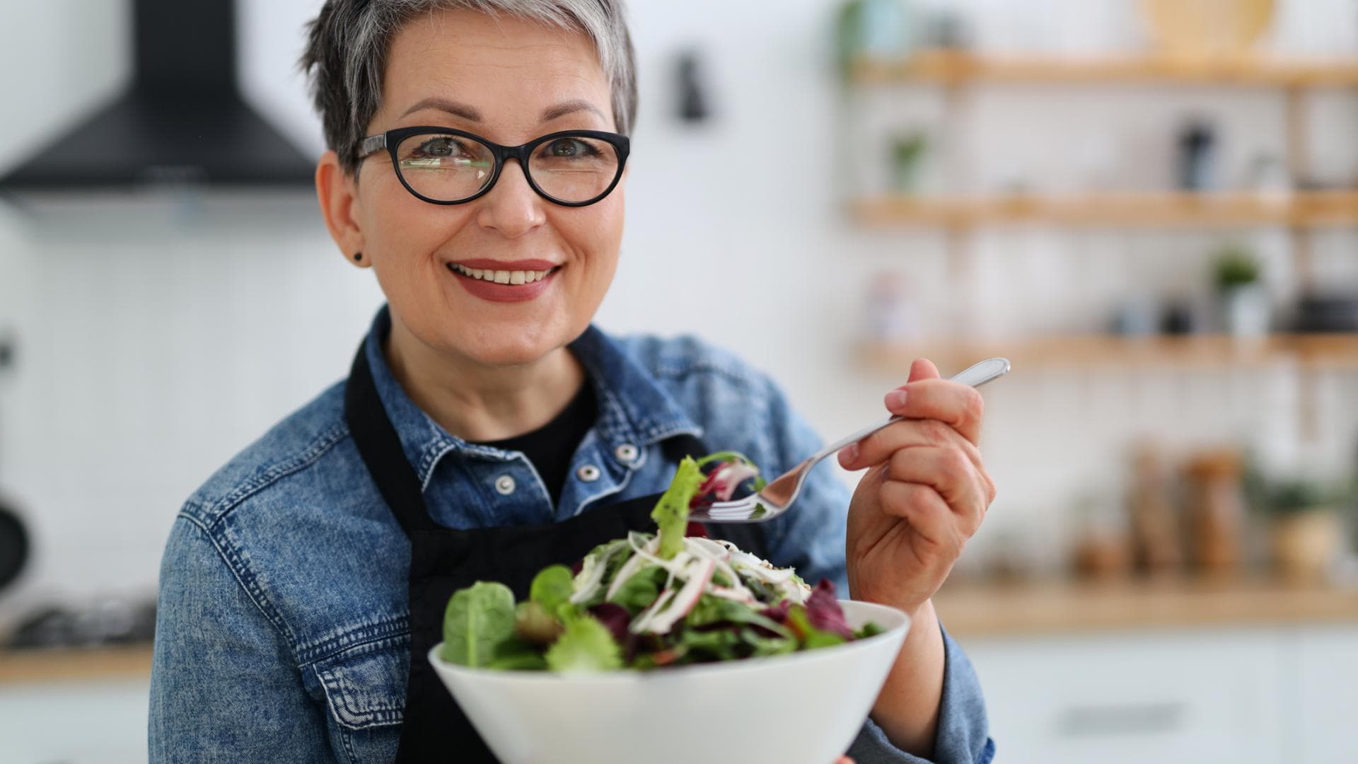 Frau im mittleren Alter isst Salat