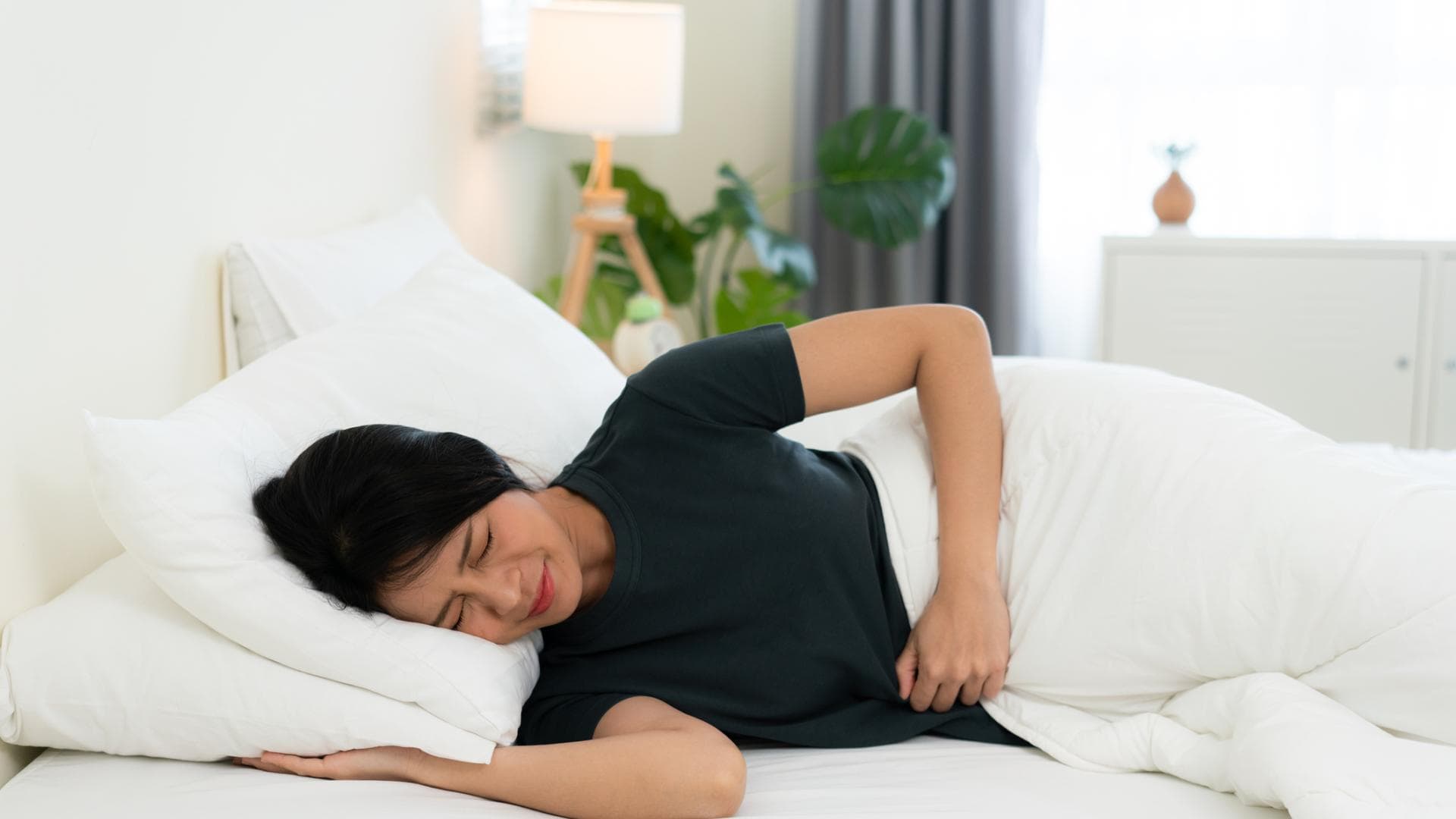 Frau im Bett mit Schmerzen