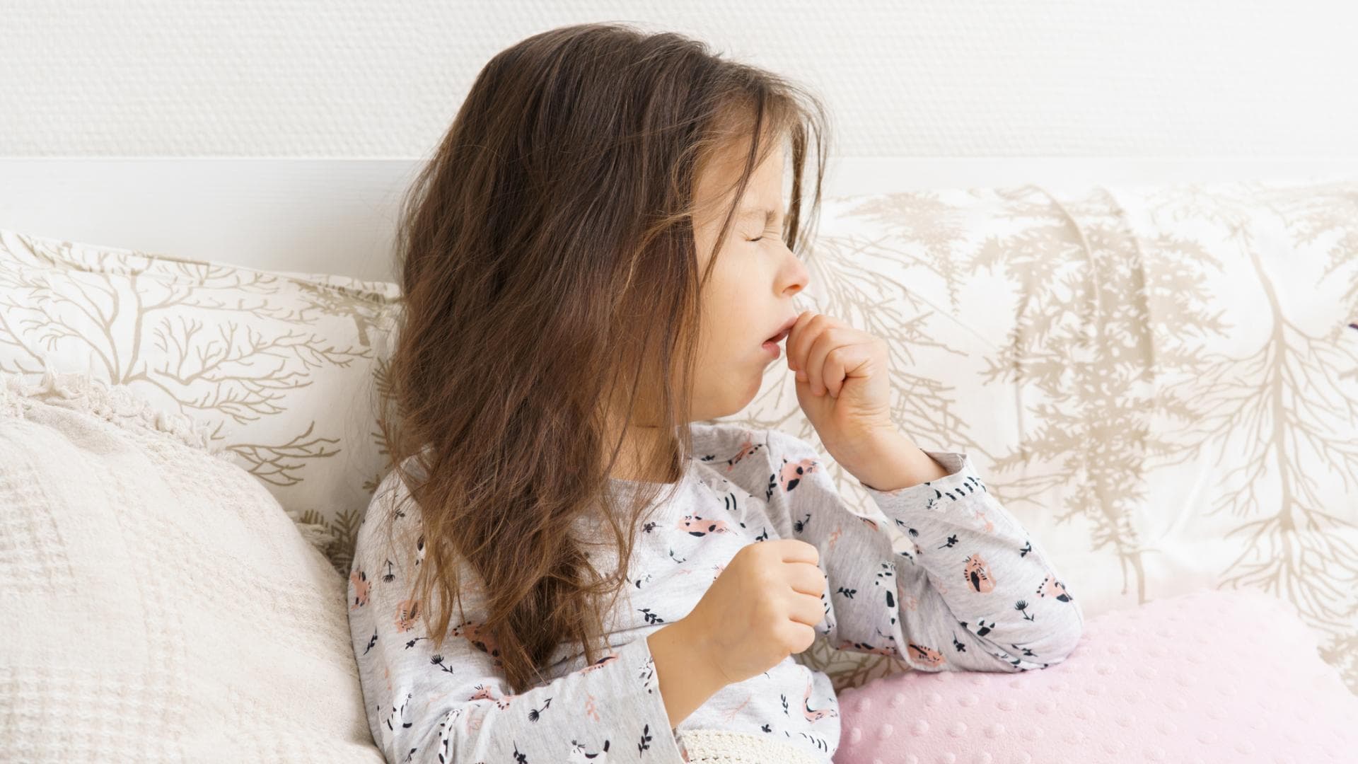 Mädchen liegt im Bett und hustet Mädchen liegt im Bett und hustet