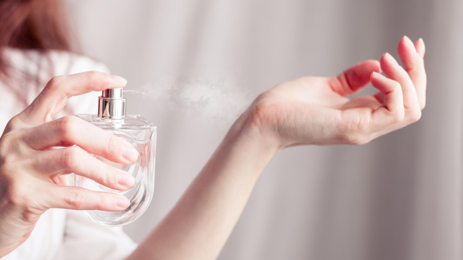 Frau trägt Parfum auf