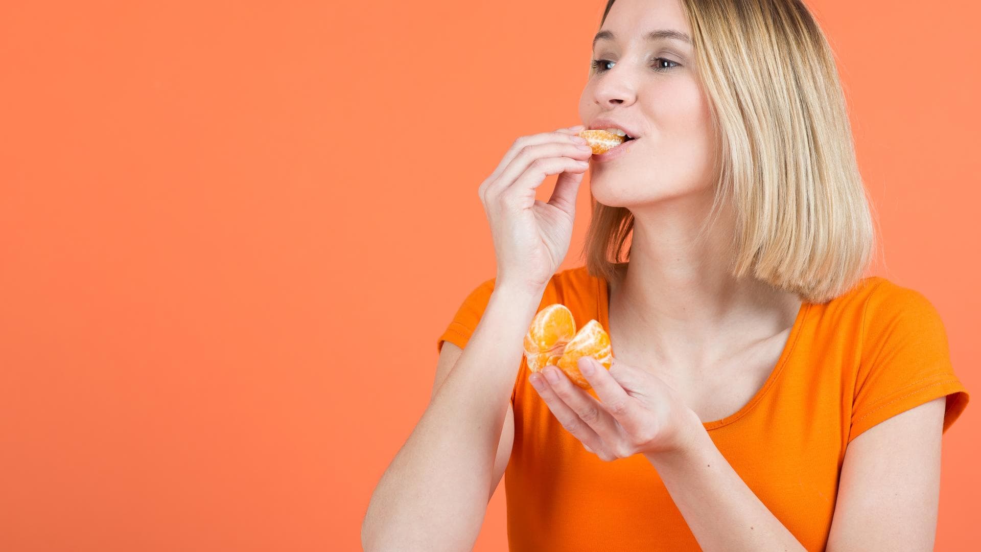 Frau beißt in Mandarine
